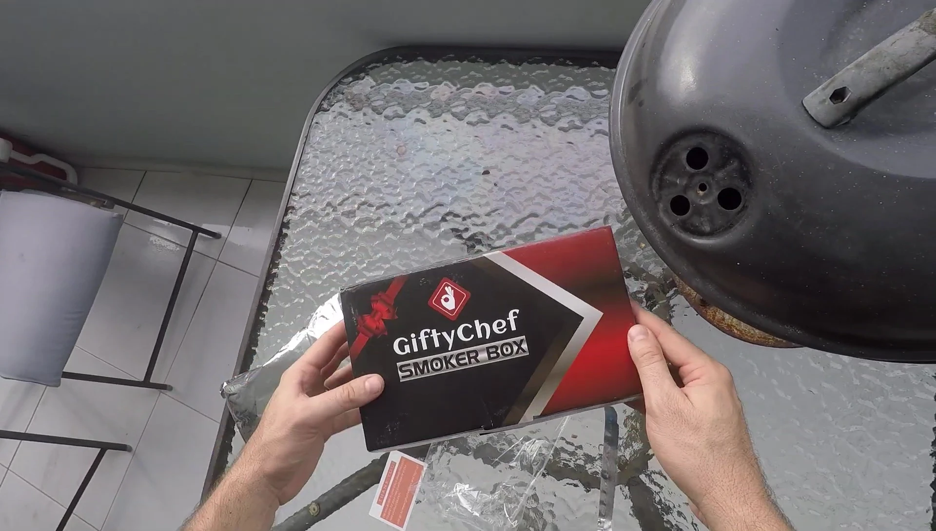 The smoker box shown on a grill, highlighting its size and suitability for various grill types.