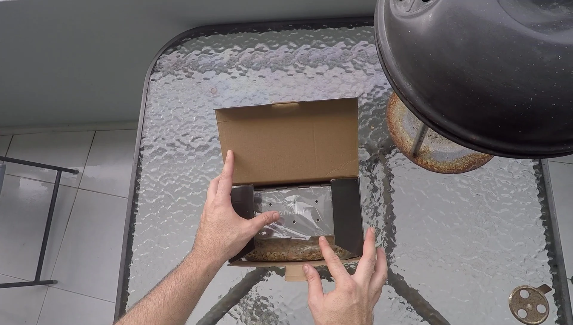 Close-up of the opened smoker box, showcasing its shiny stainless steel construction.