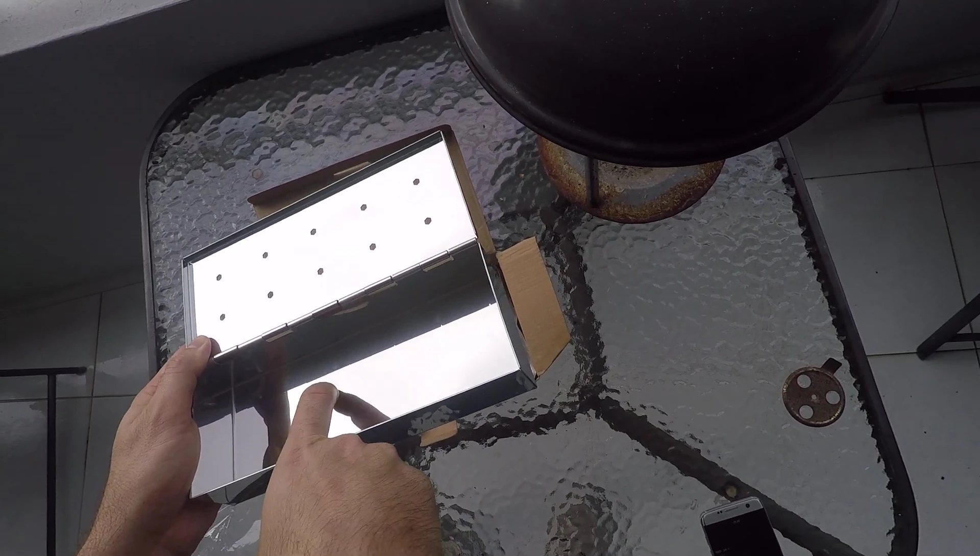 Close-up of the smoker box highlighting the absence of holes in the bottom.