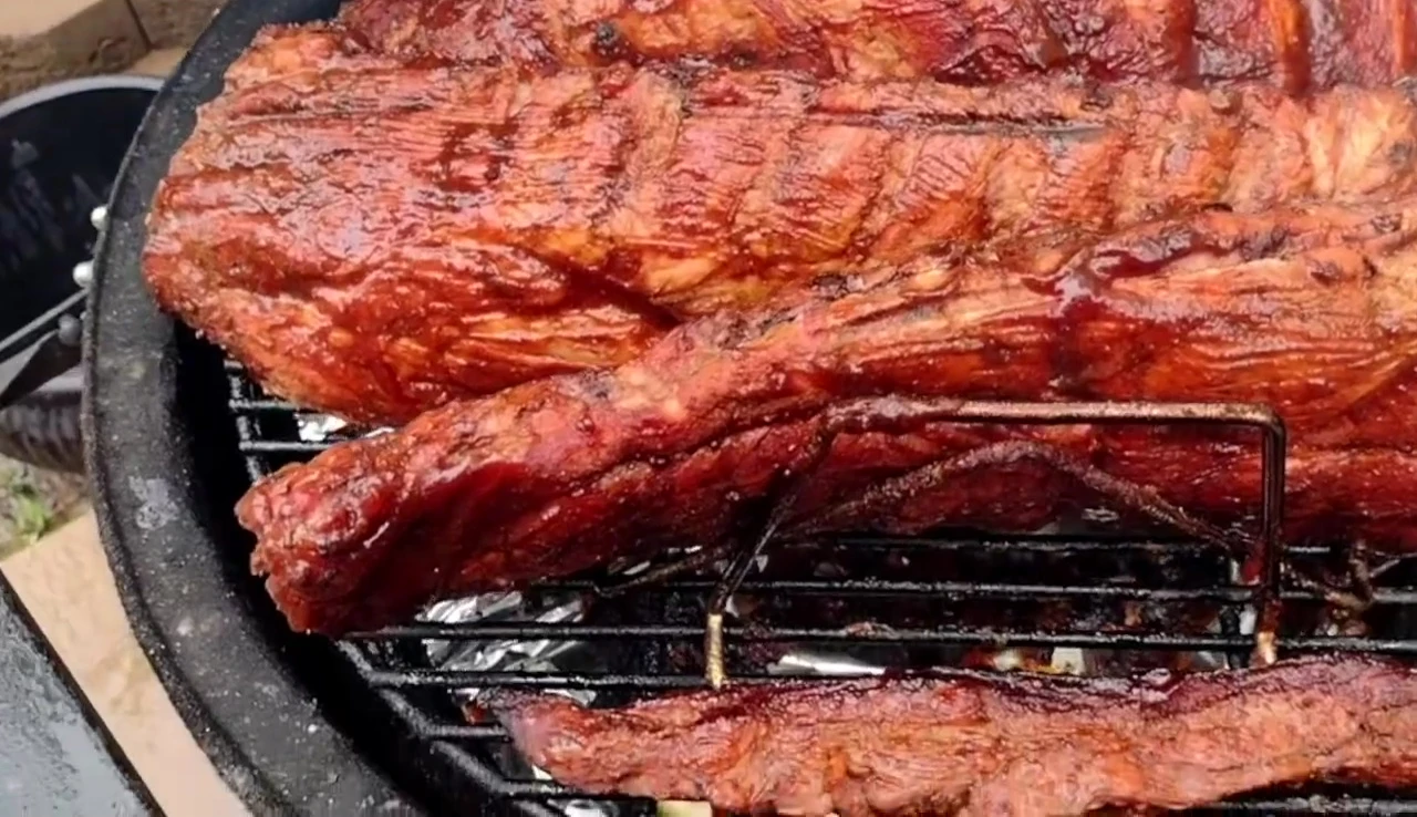 The rib rack positioned within the Kamado Joe grill, showing the spacing between ribs.