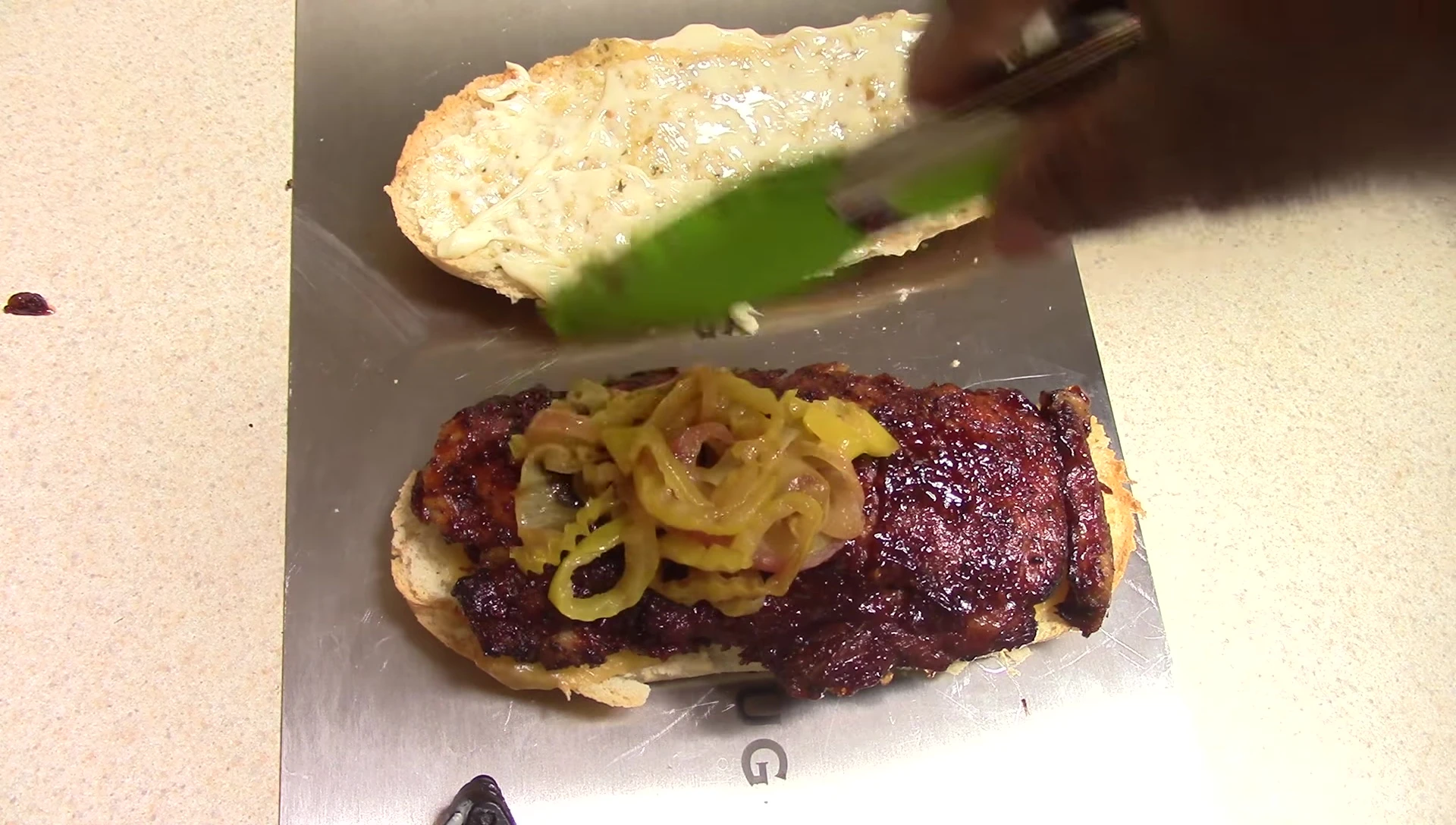 Adding sauteed onions and peppers to the sandwich.