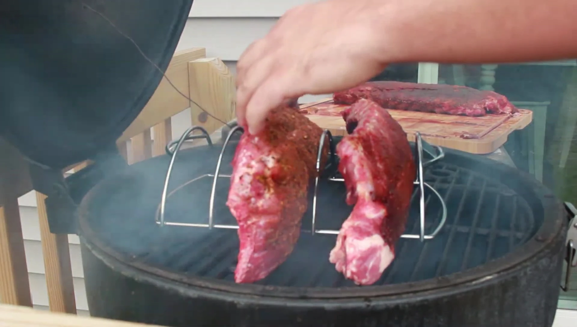 Placing ribs on the smoker rack.