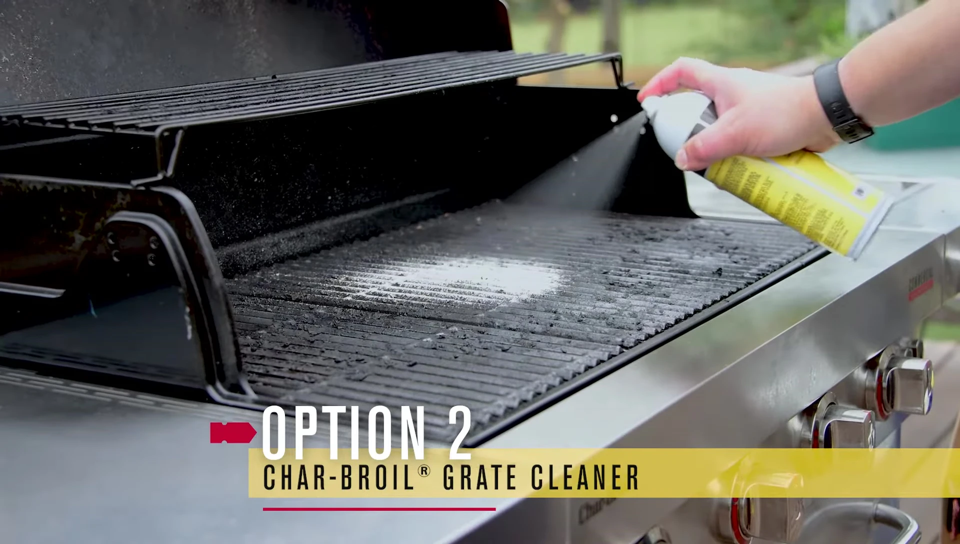 Spraying the Char-Broil grill cleaning spray on the grates.