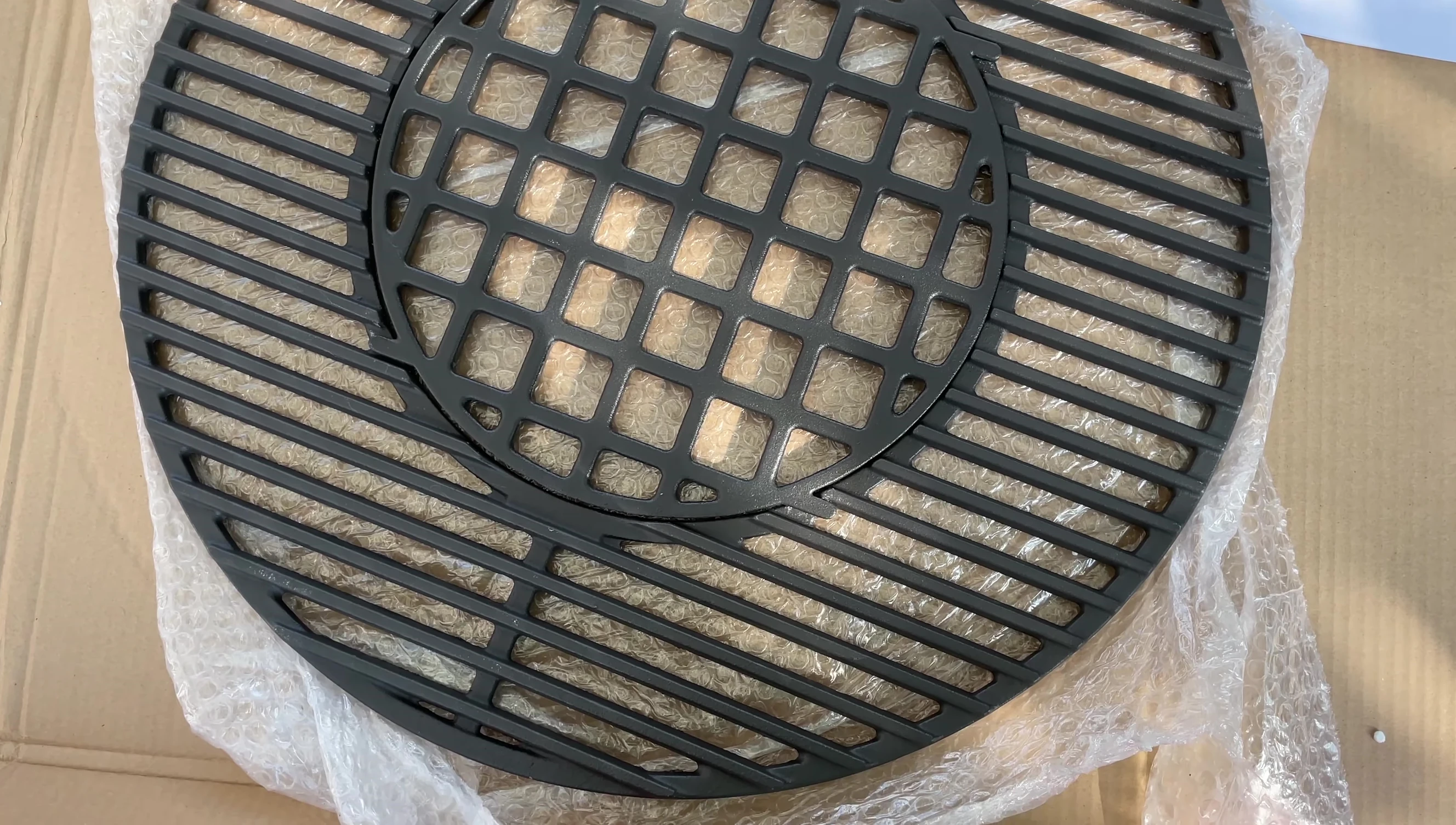 The reviewer showcasing the grate's design and its capability for achieving good grill marks.