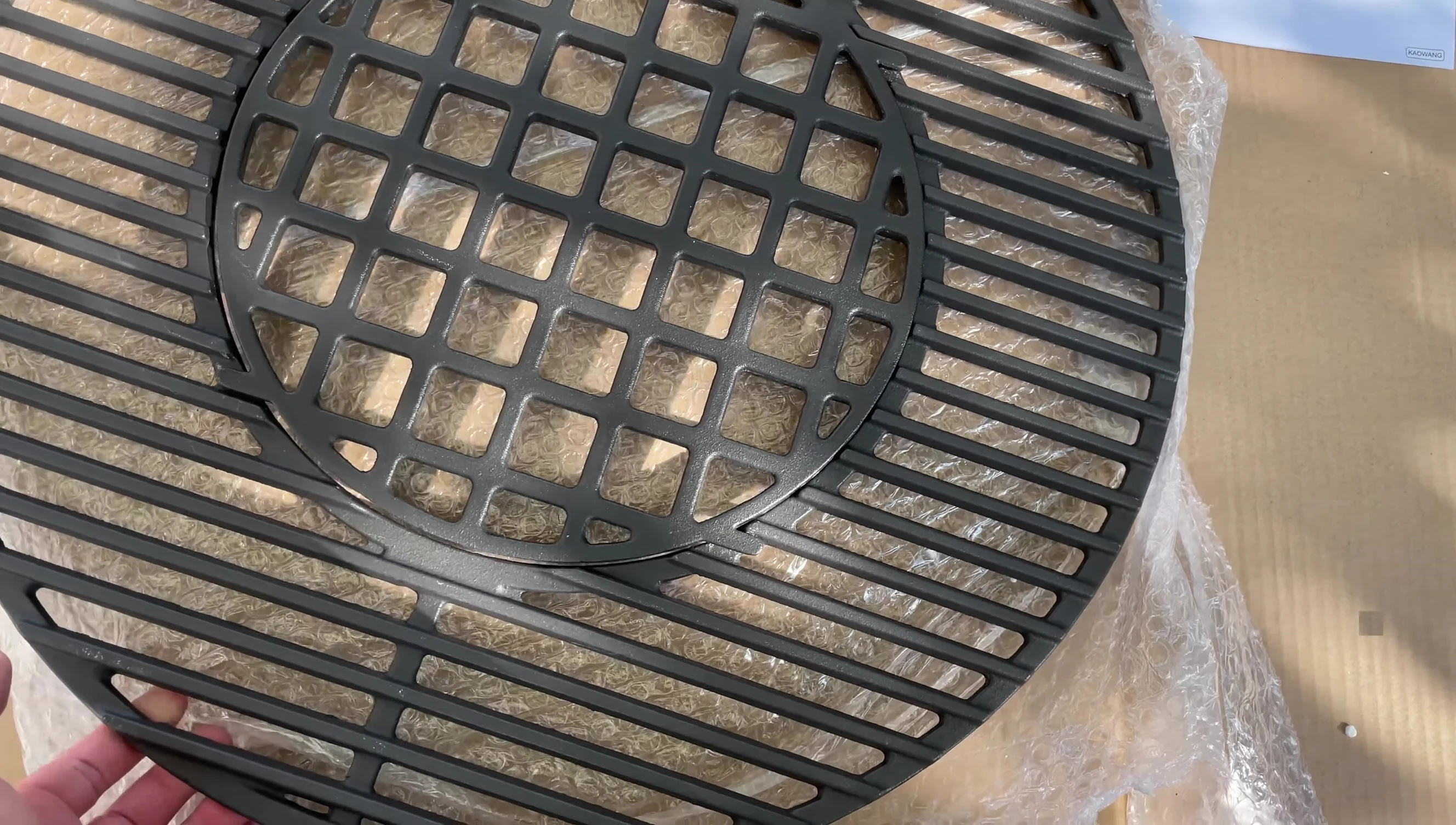 The reviewer holding the grill grate, emphasizing its weight and solid construction.