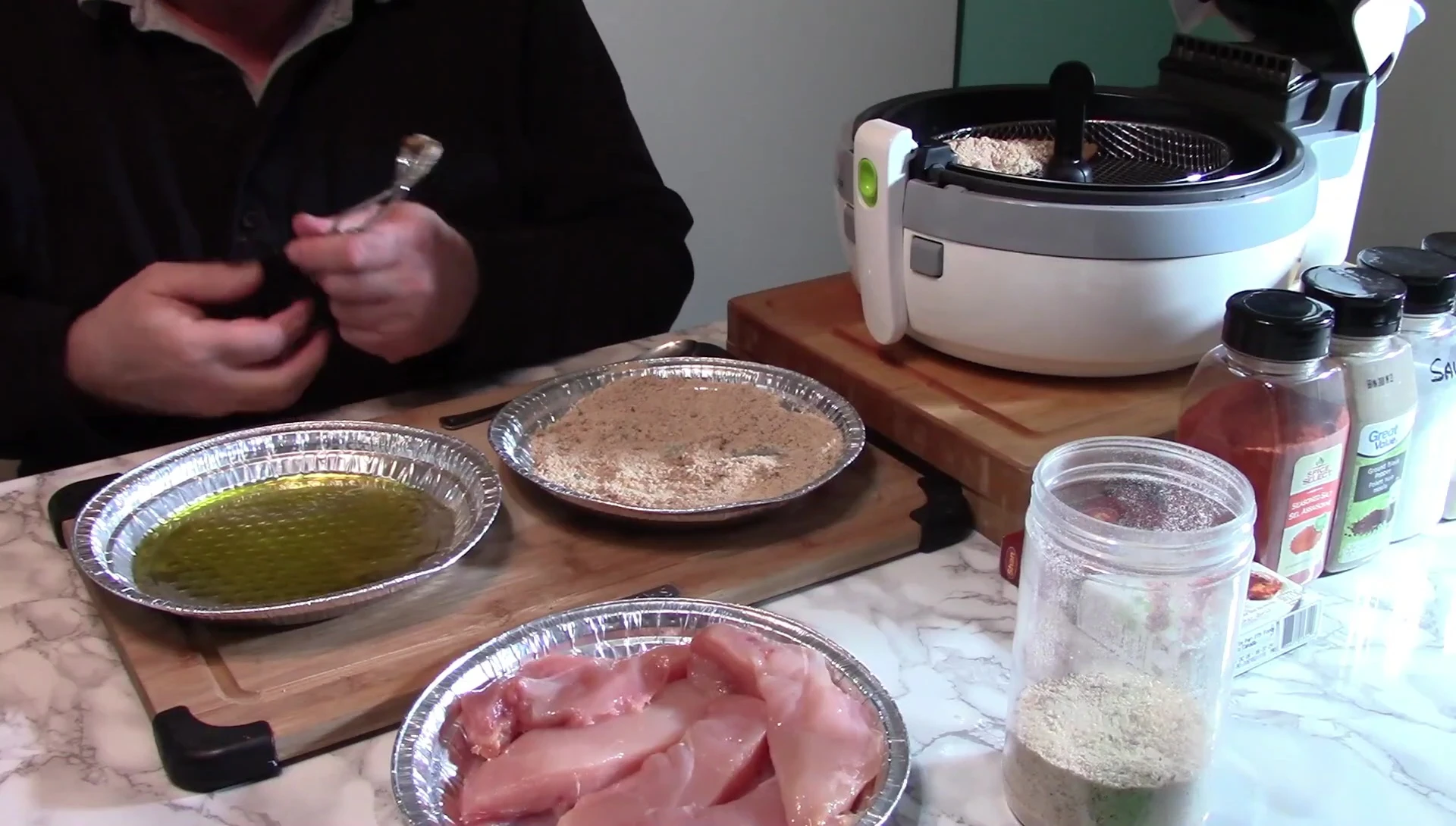 Chicken pieces being breaded.