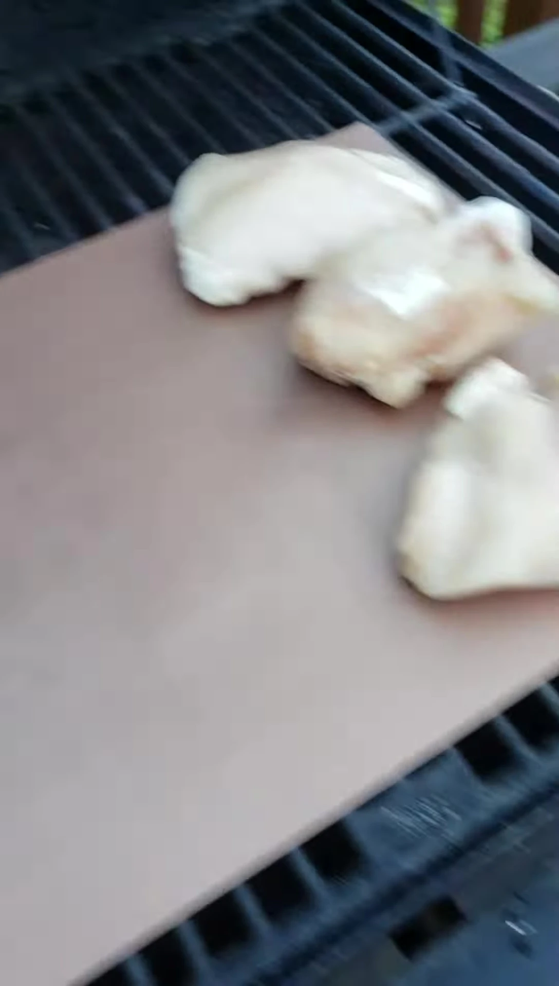 Steak being placed on the Gotham Copper Grill Mat.