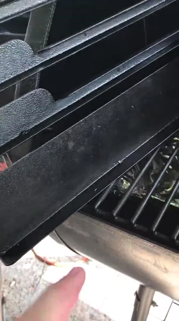 Close-up of the bracket's placement under the grill grates.