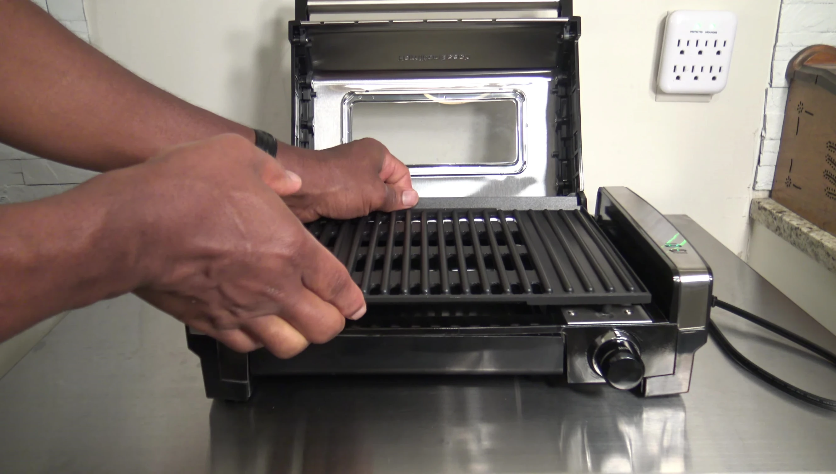 Demonstrating the easy removal of the grill plate.