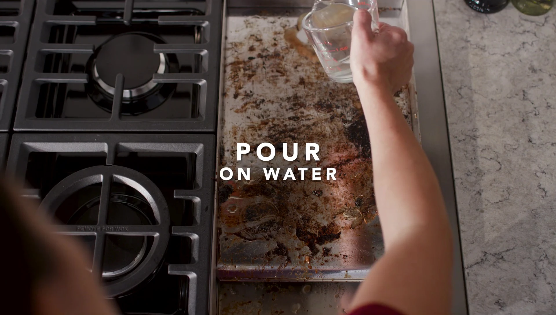 Water being poured onto the hot griddle surface.
