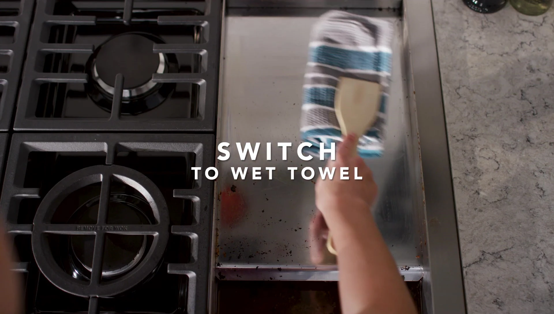 Wiping the griddle with a wet towel.