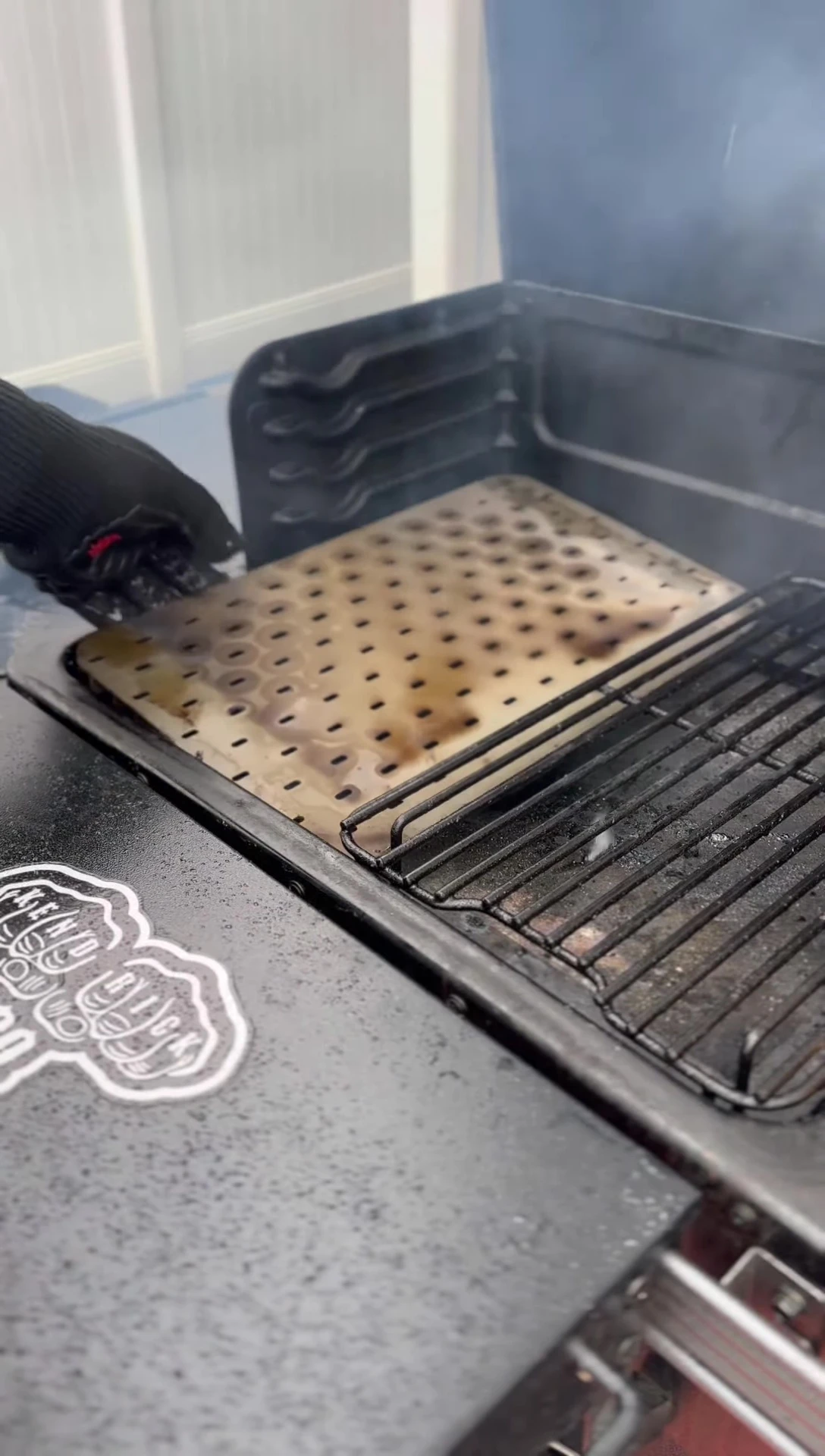 Using heat-resistant gloves to handle the hot grate.