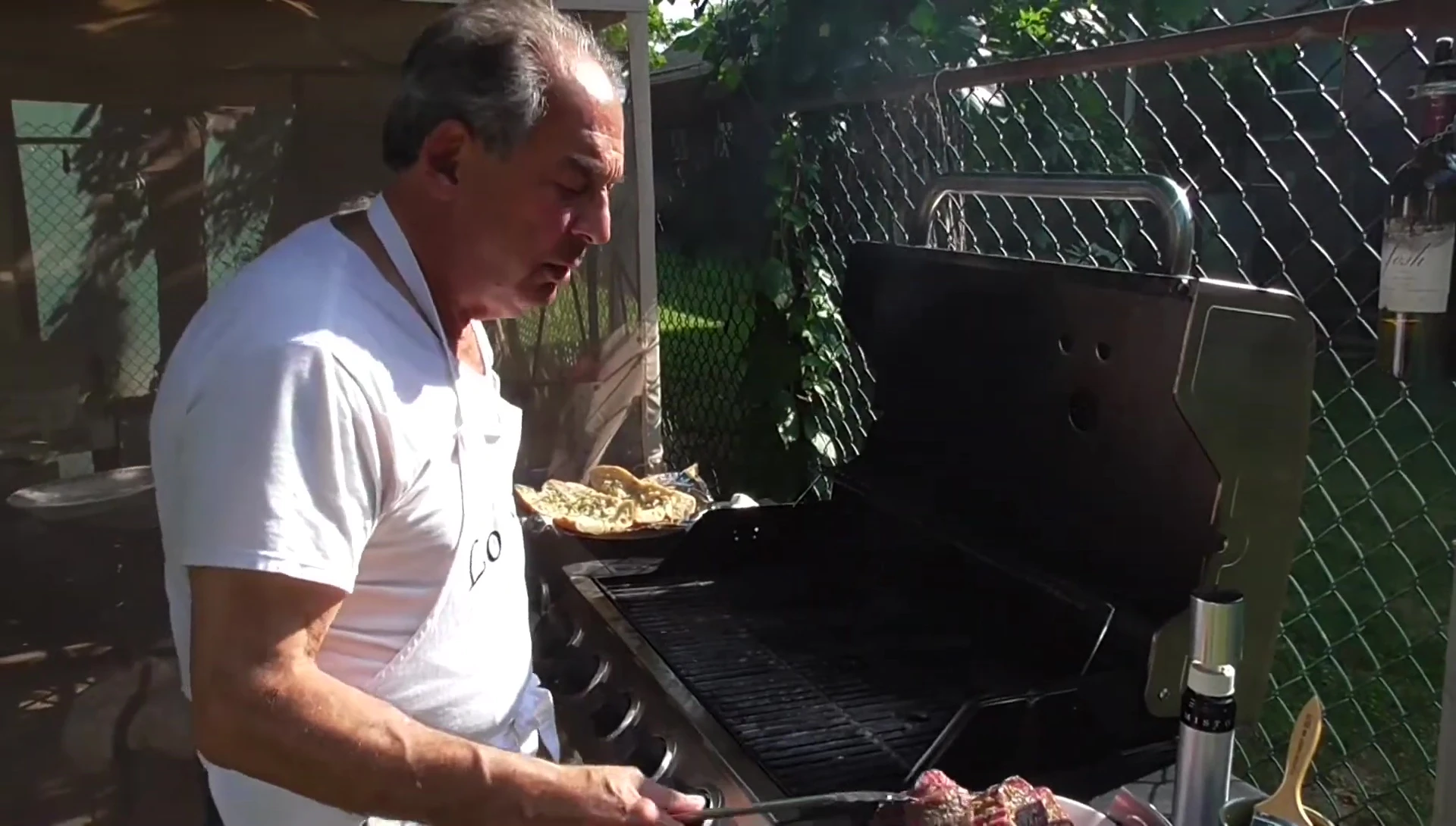 The steaks being placed on the barbecue