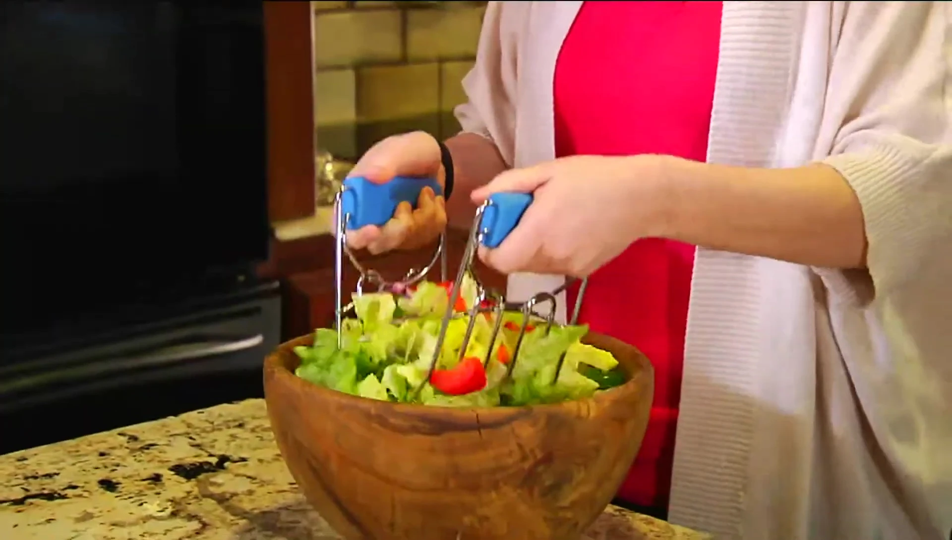 Presenter using the claws to toss a salad