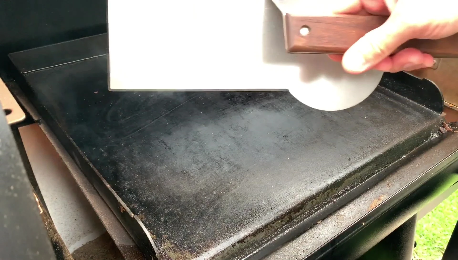 Griddle press being used to smash burger patties