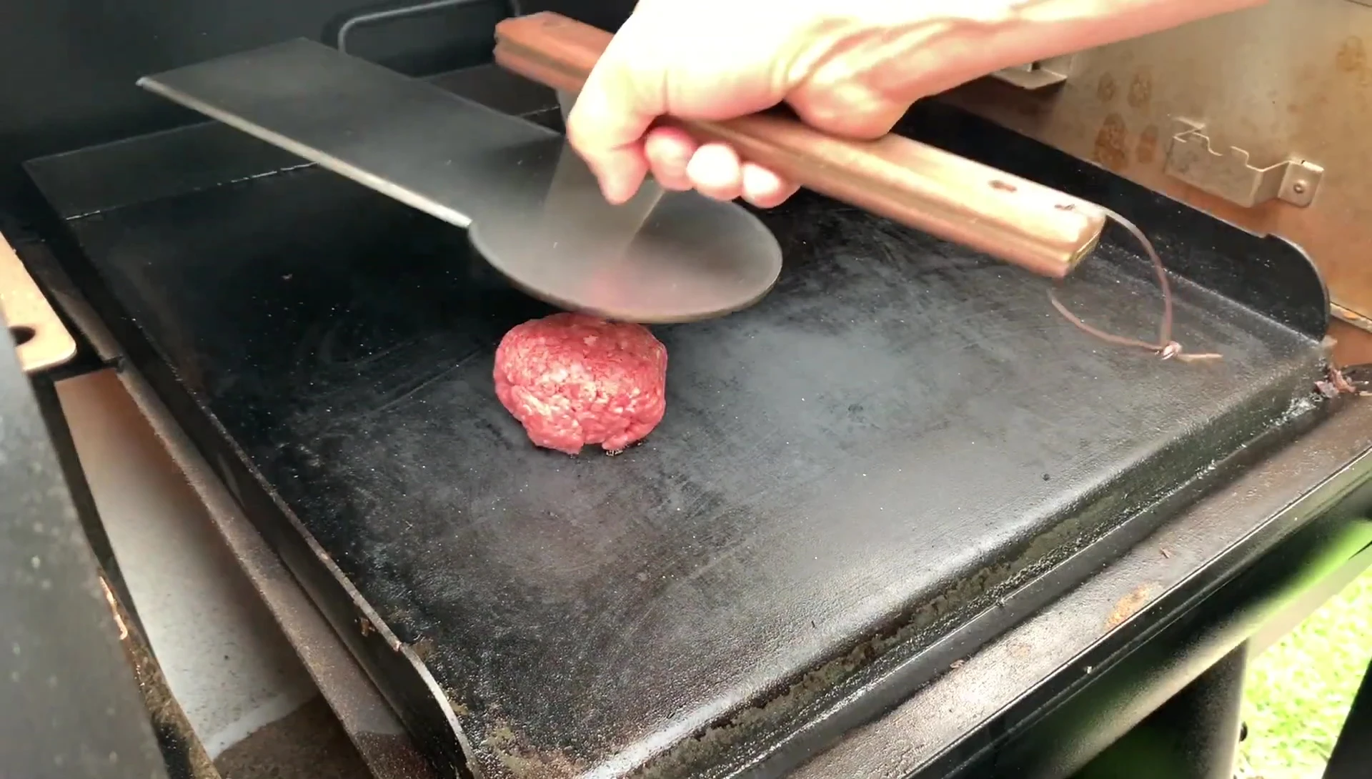 Burgers being smashed on the hot griddle