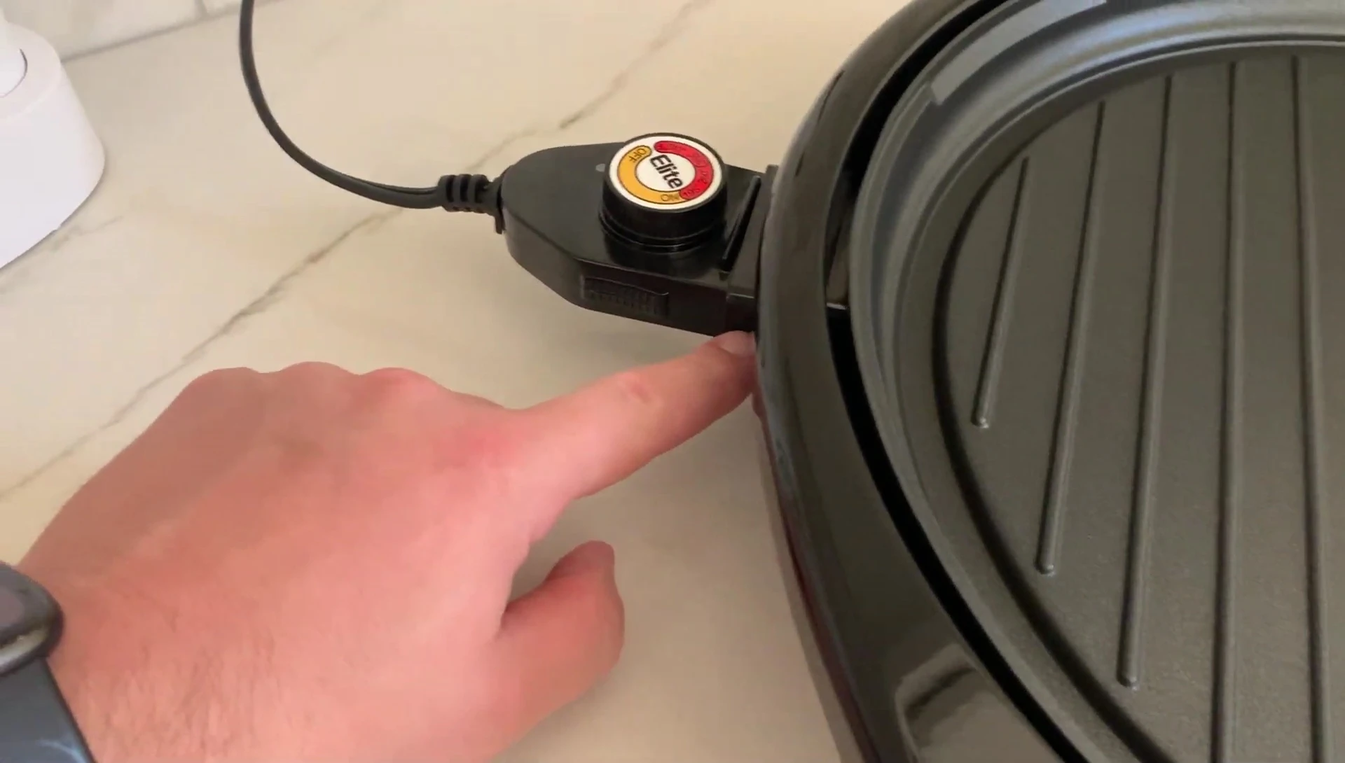The reviewer demonstrating how the heating element and plate detach for cleaning.