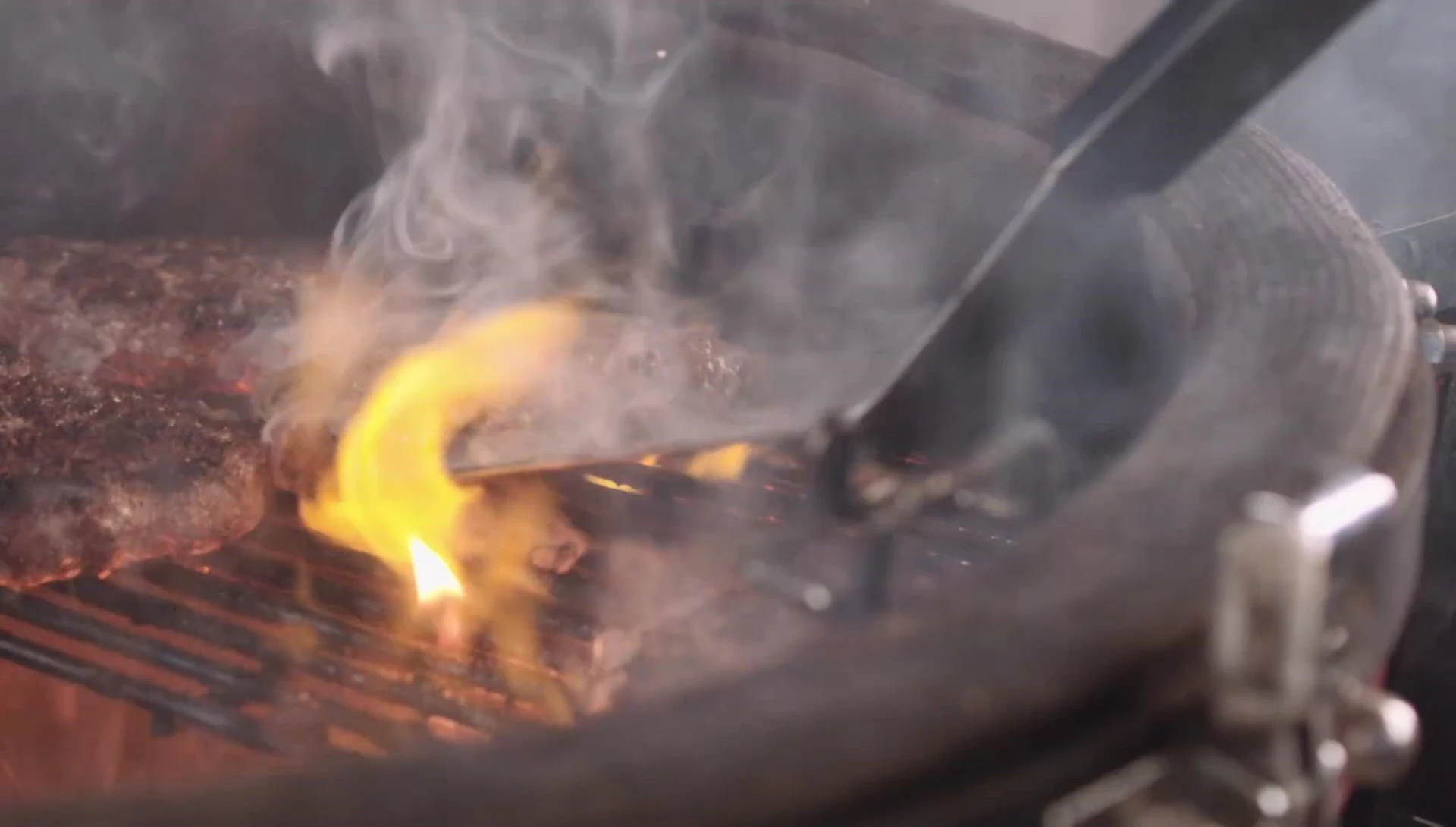 The turner being used to flip food on a grill.