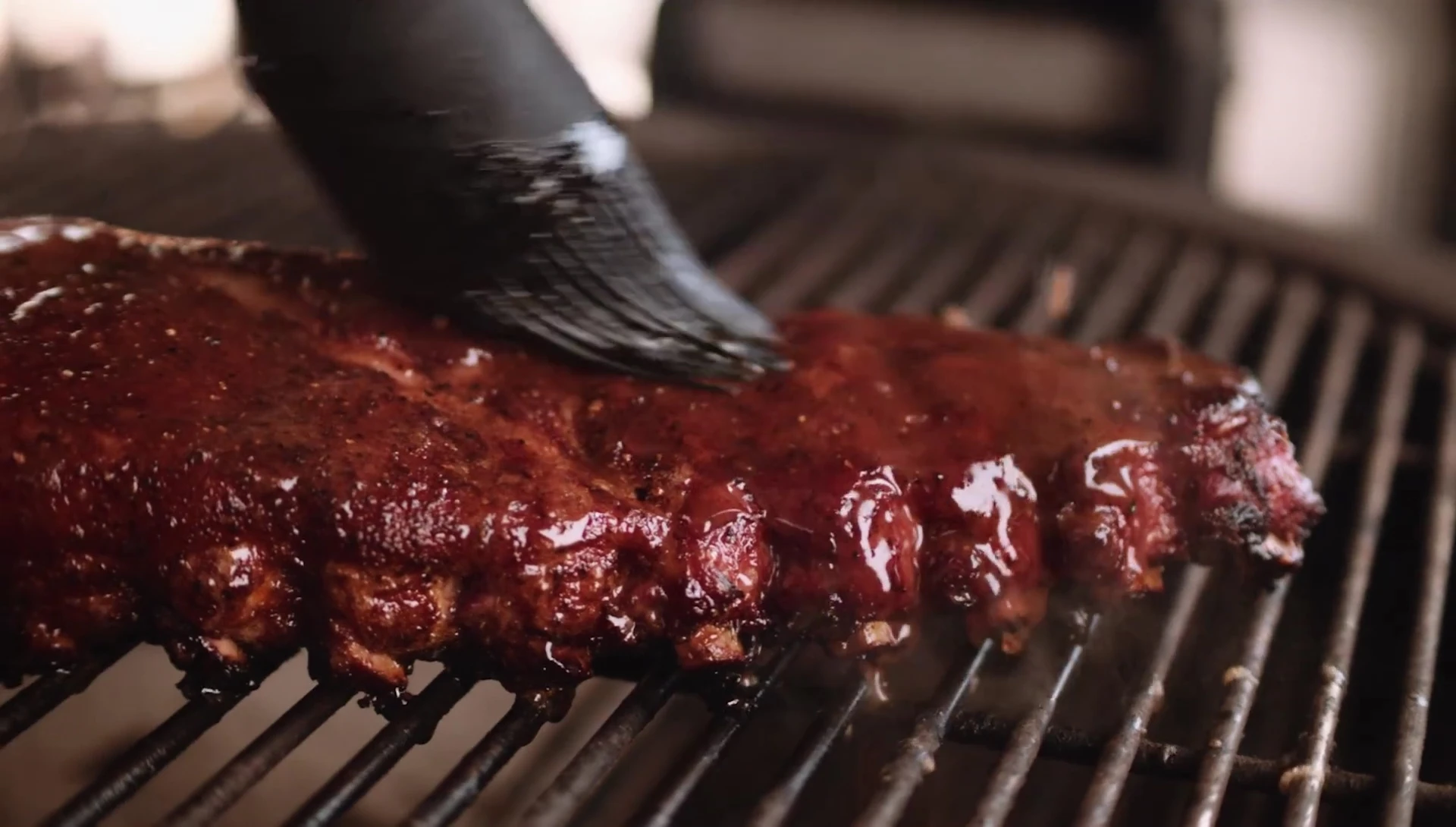 The basting head of the brush being used to apply a marinade.
