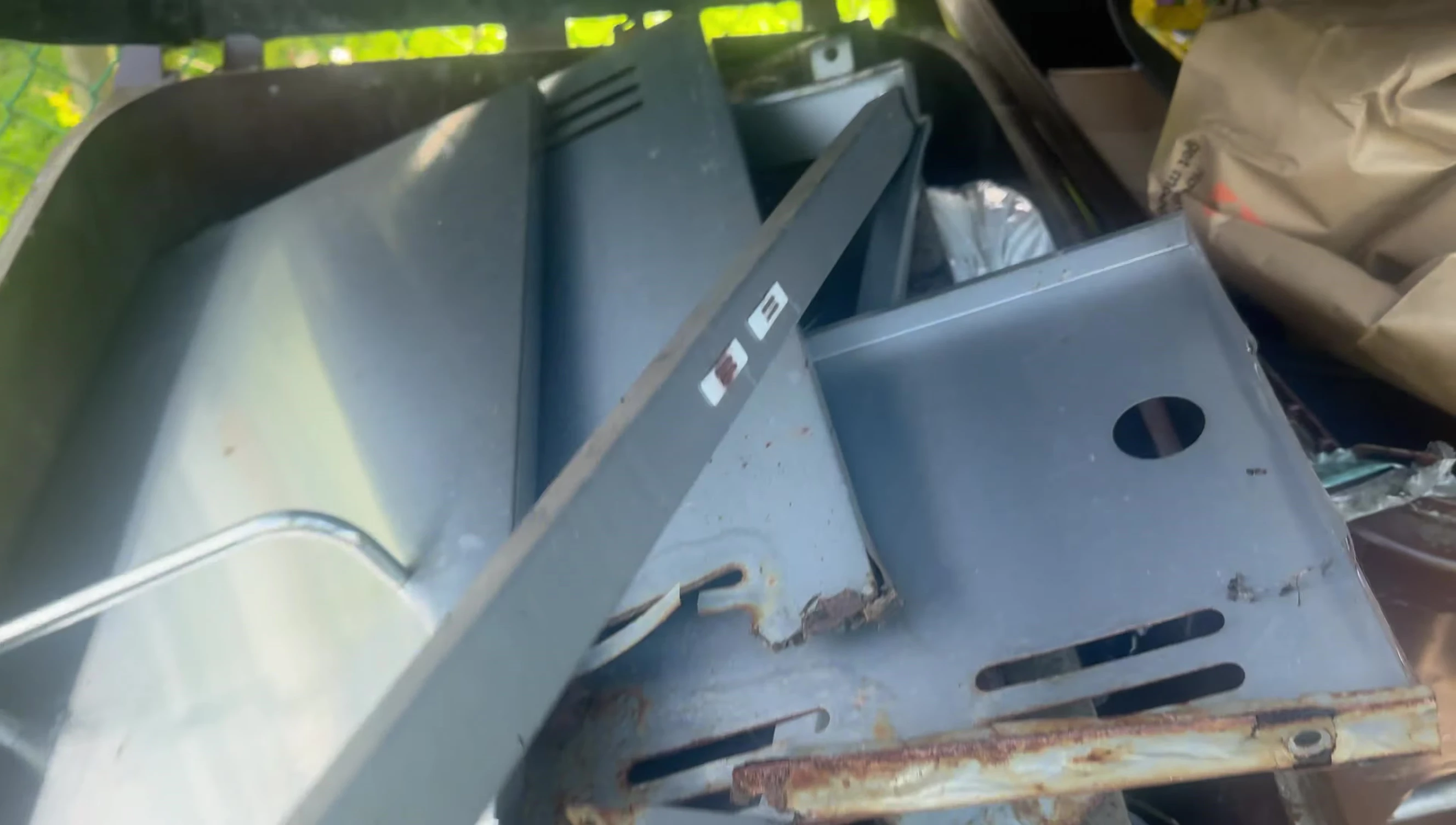 Close-up view of the significant rust damage on the grill, showing the separation between the top and base.