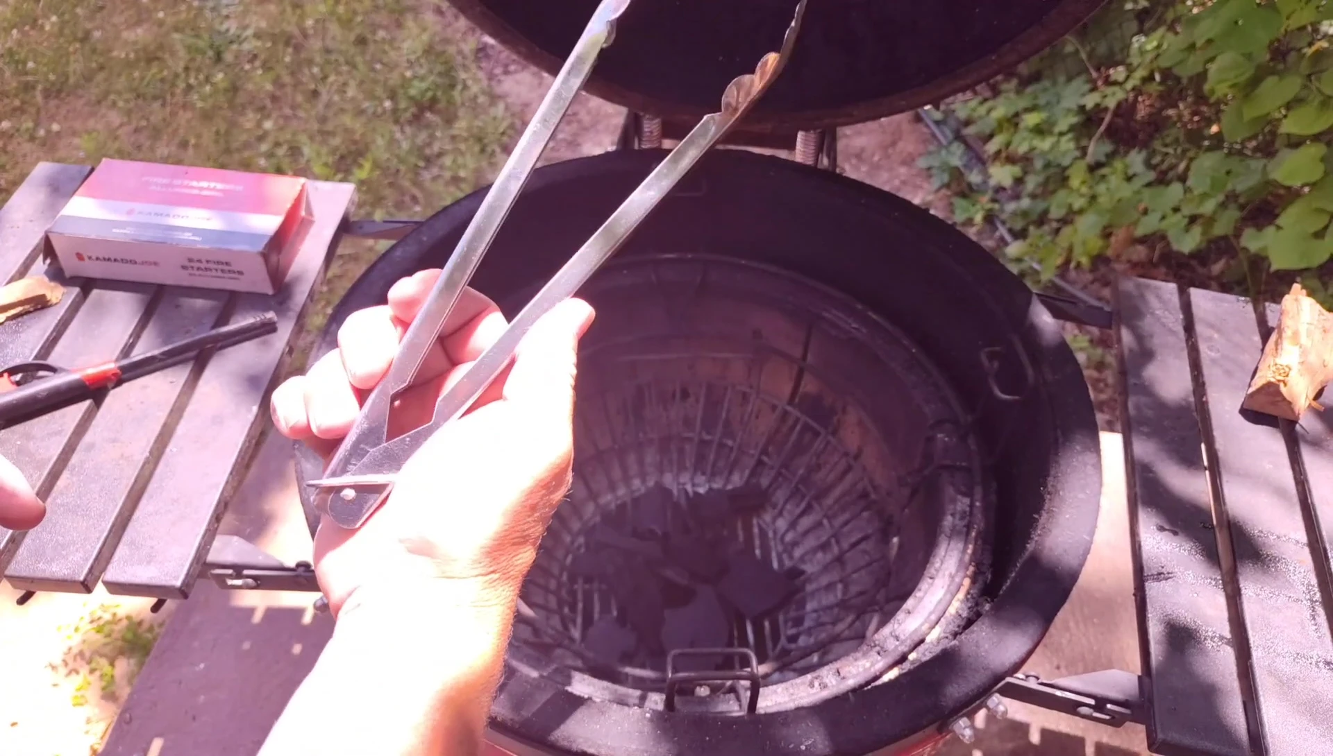 Using specialized tongs to handle the charcoal.