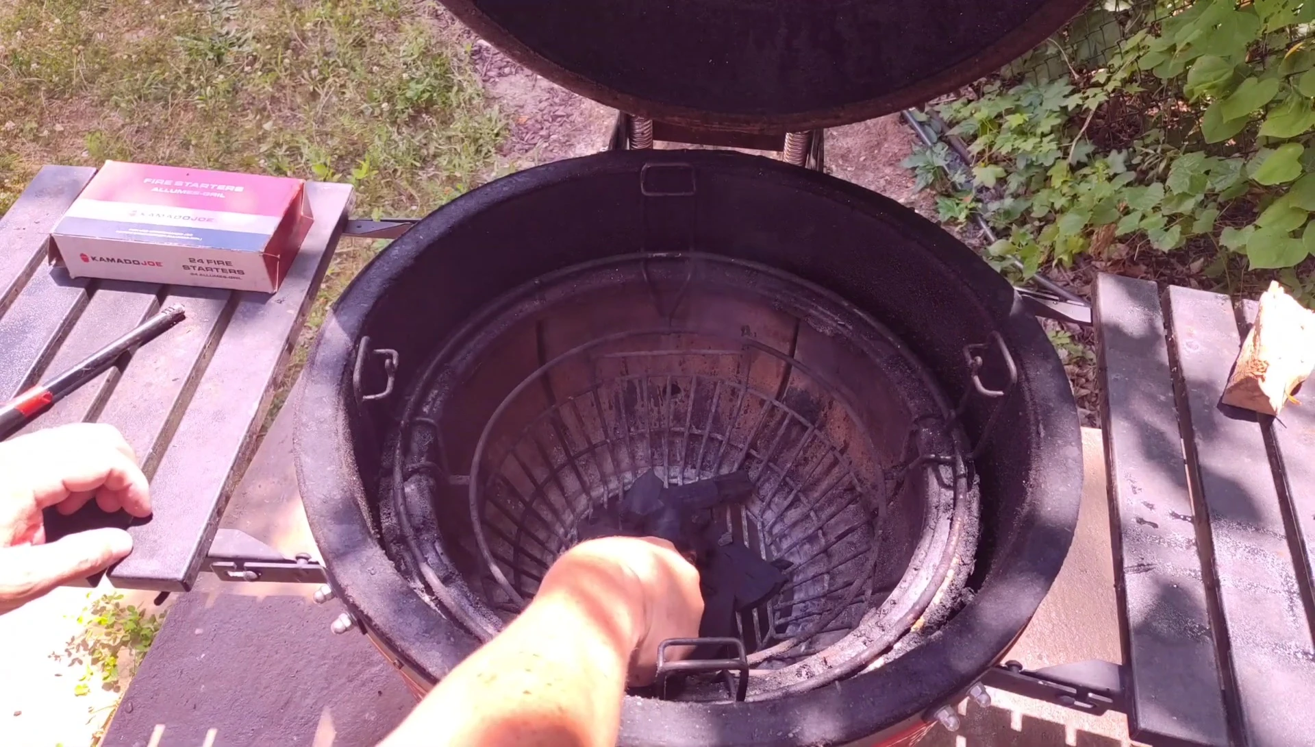 Placing fire starters and building a small pile of charcoal around it.