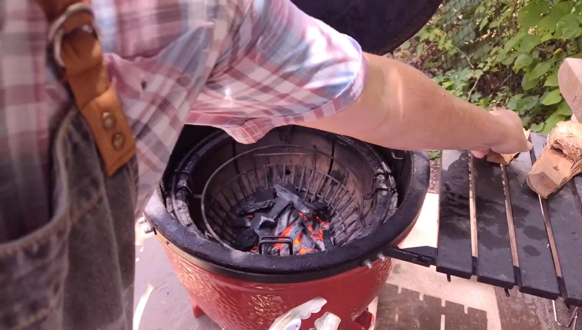 Adding wood chips to the kamado grill.