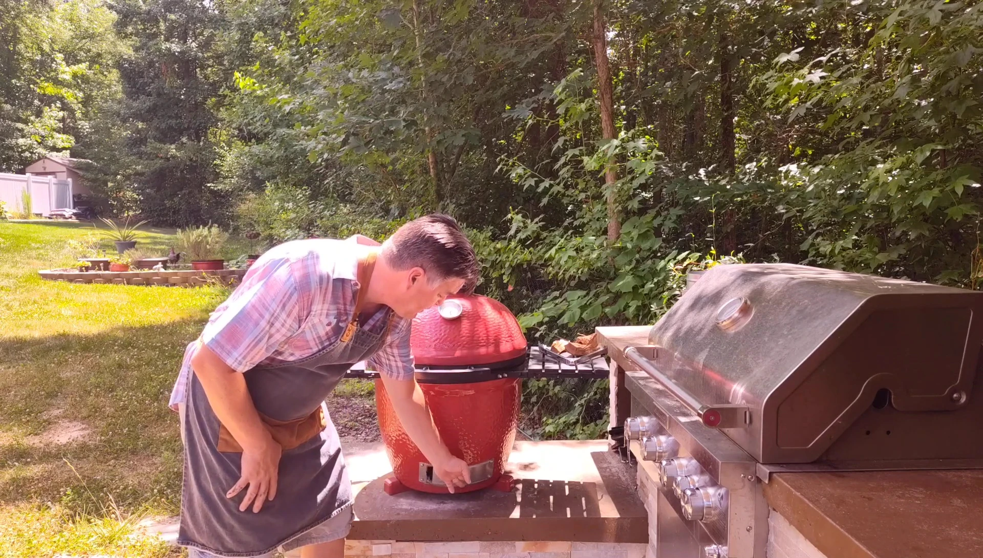 Opening the bottom vent of the kamado grill.