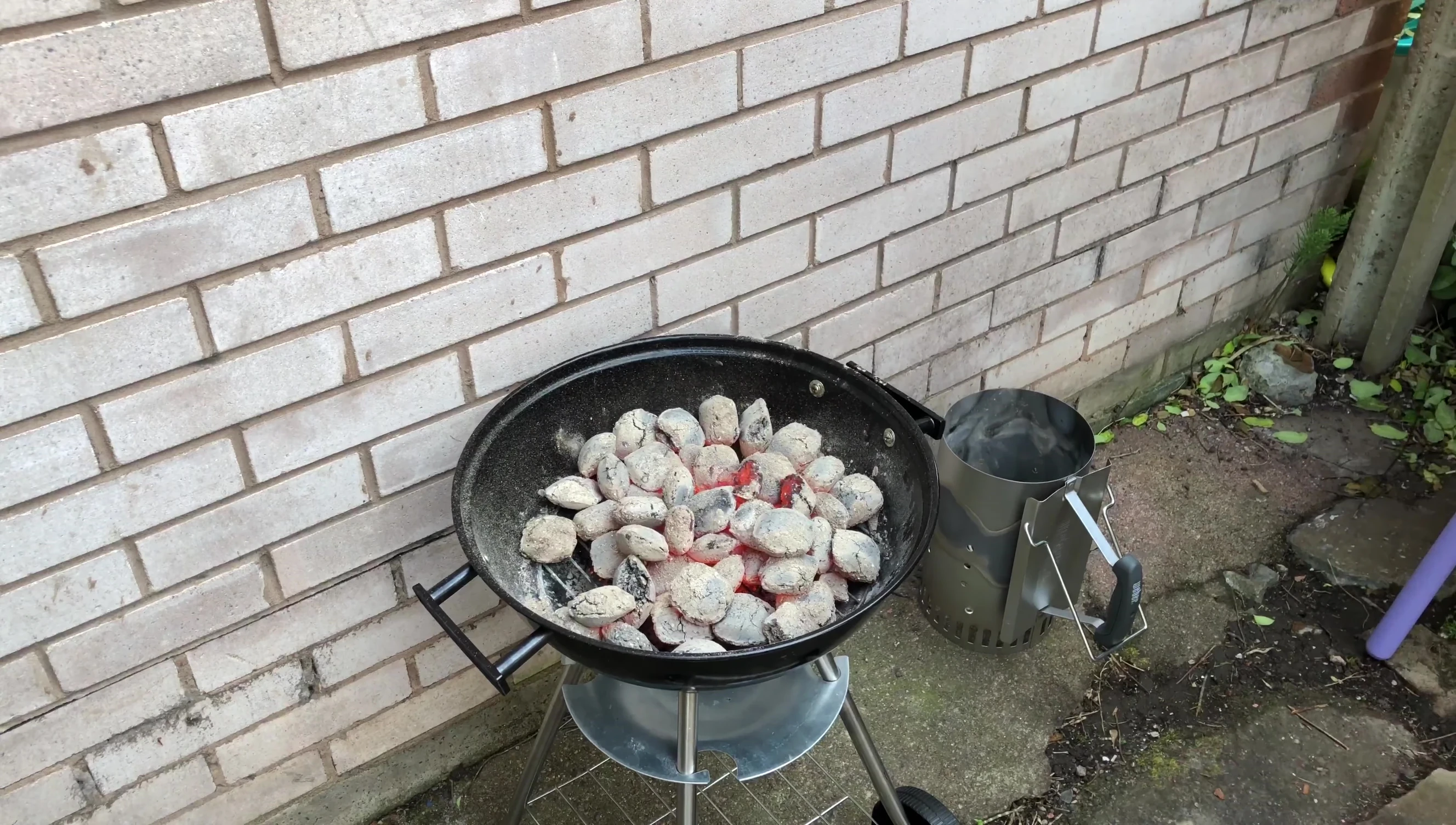 Emptying hot coals onto the barbecue grill