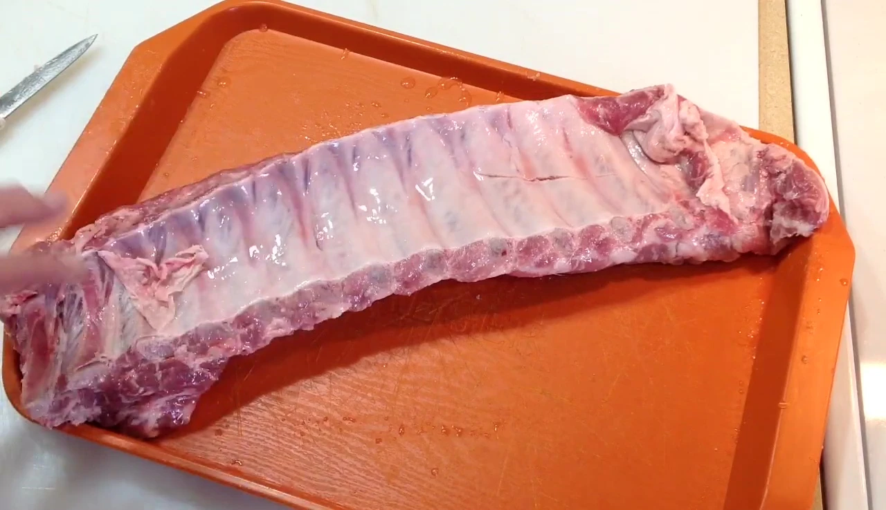 Close-up of removing silver skin from a rib rack.