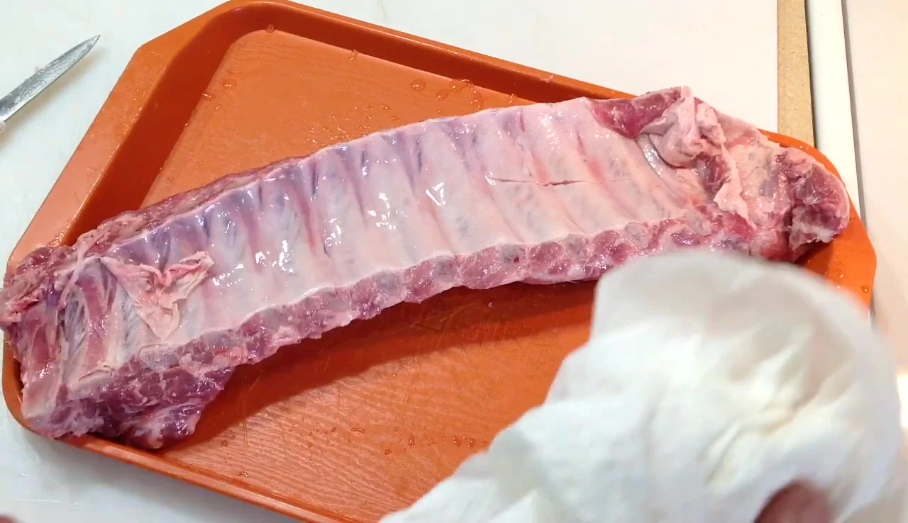 Using a paper towel to peel the silver skin.