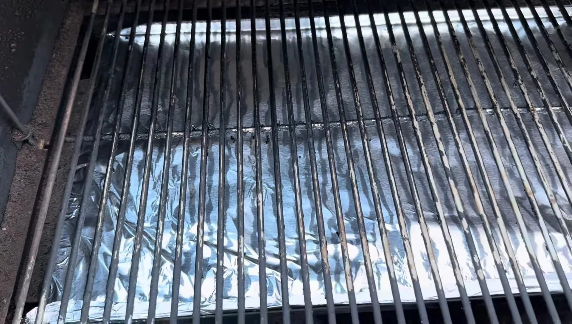 The user using brillo pads to further clean the grill.