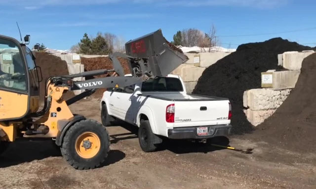 A truck delivering bags of cedar mulch.