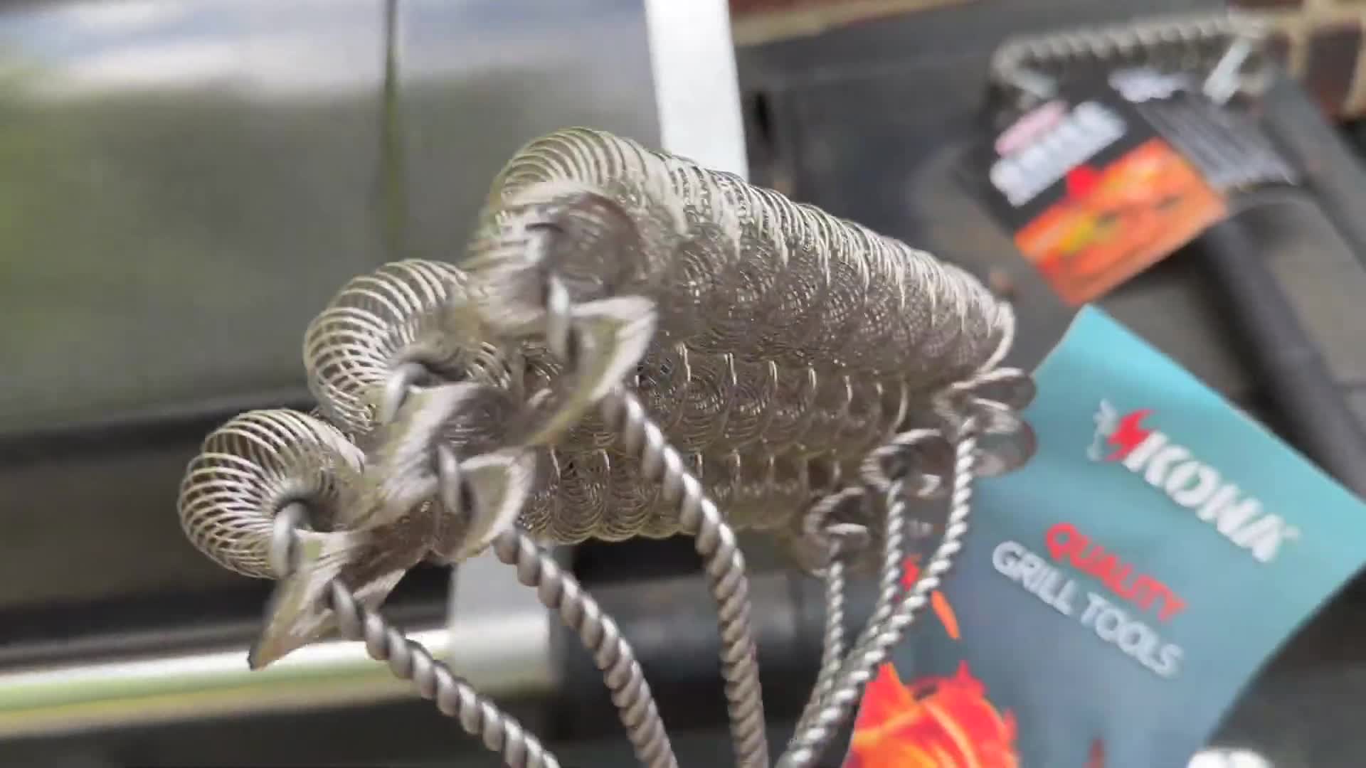 Transition to the Grillart scraper showing its single row of wire loops and bristles.