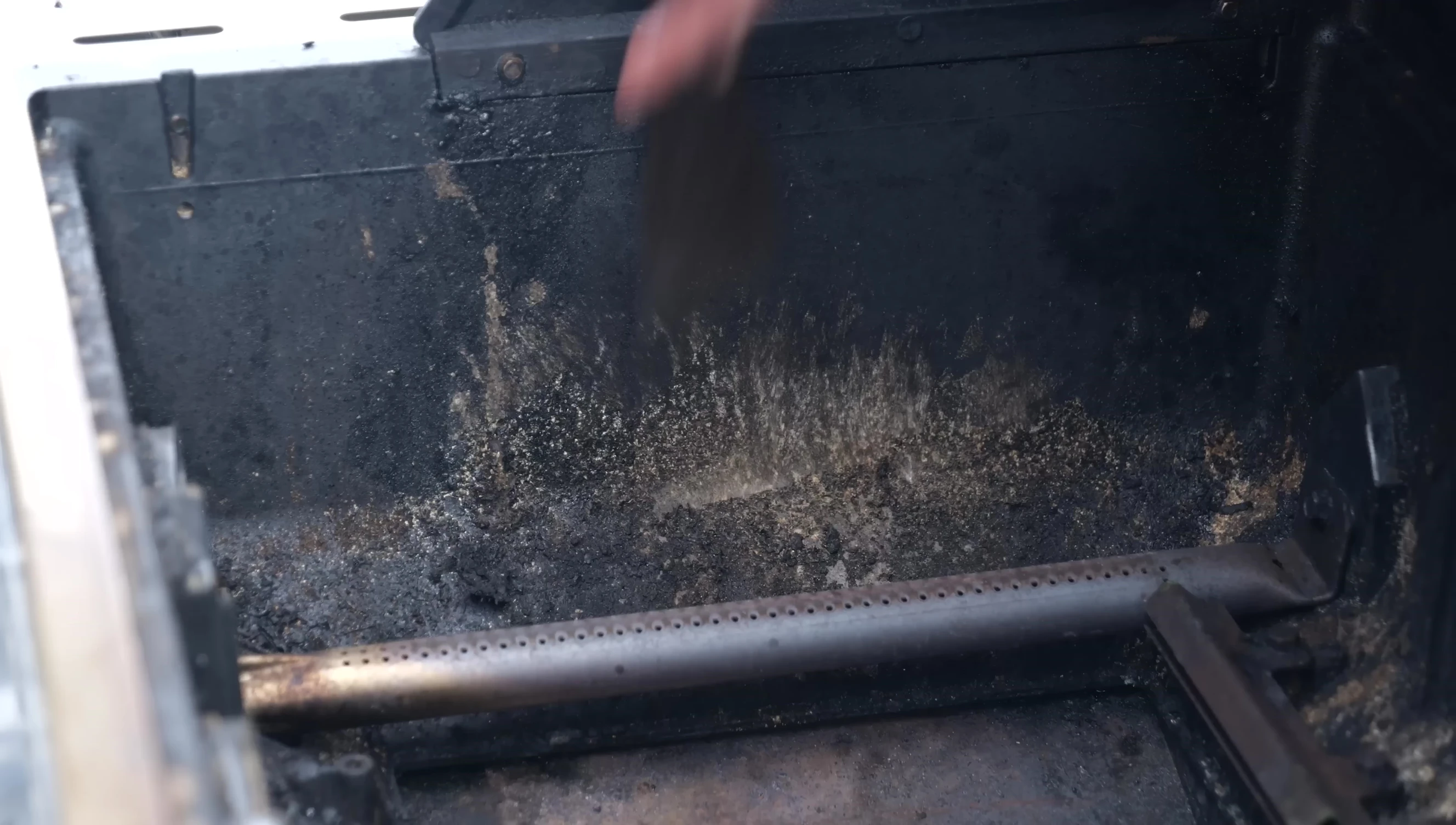 Using a spatula to scrape off large chunks of dirt