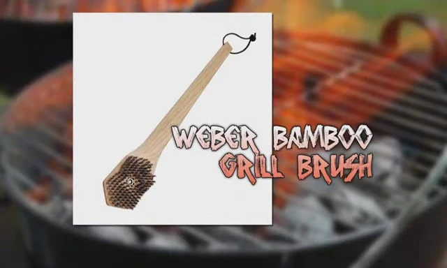 The Weber brush being used to clean a grill.
