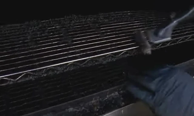 The Grill Stone being used to clean a grill grate.