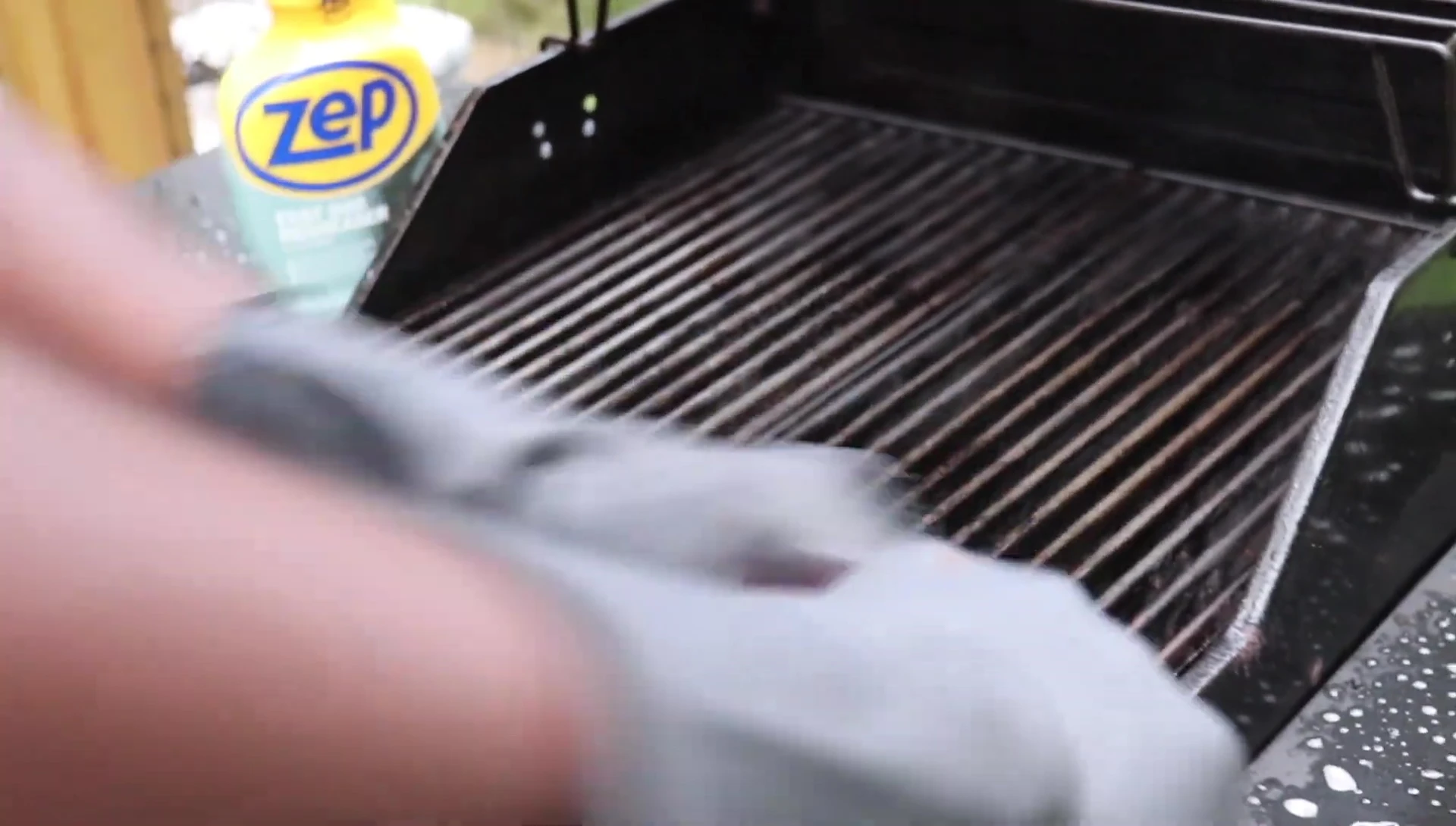 Scrubbing the grill grates with a brush