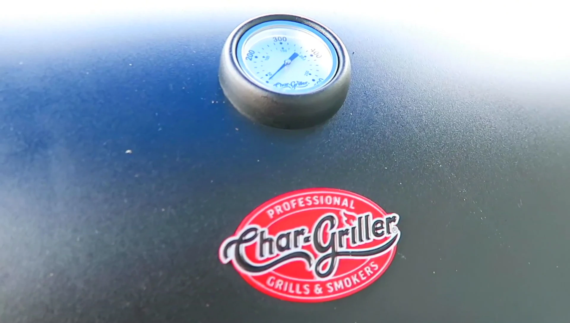 Close-up of the Char-Griller Smoke Champ offset smoker being unloaded from its trailer.