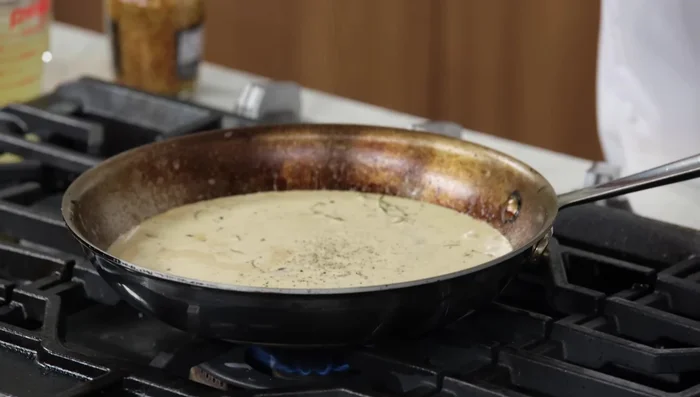 Simmer the sauce until thickened, watching for smaller, more frequent bubbles indicating a thicker consistency. Add a knob of butter at the end for richness.
