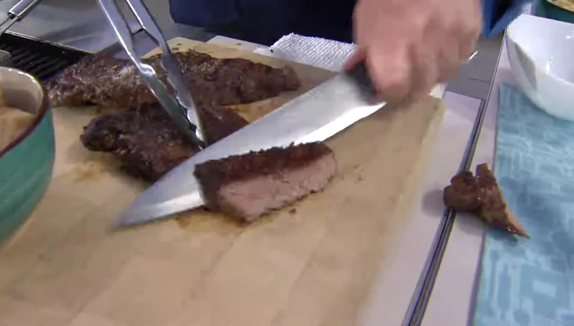Perfectly cooked steaks being lifted from the grill plate.