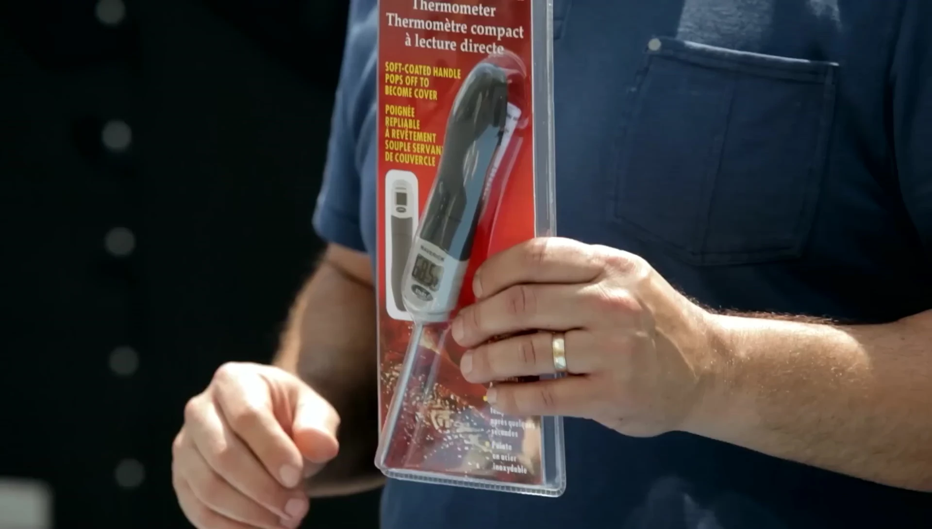 Person using the instant-read thermometer to check meat temperature.