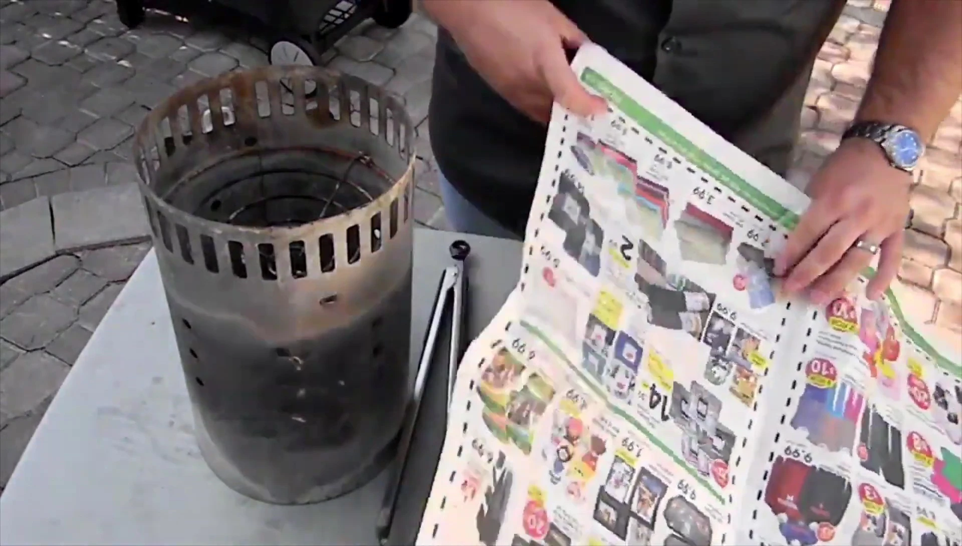 Rolling newspaper loosely for charcoal chimney starter