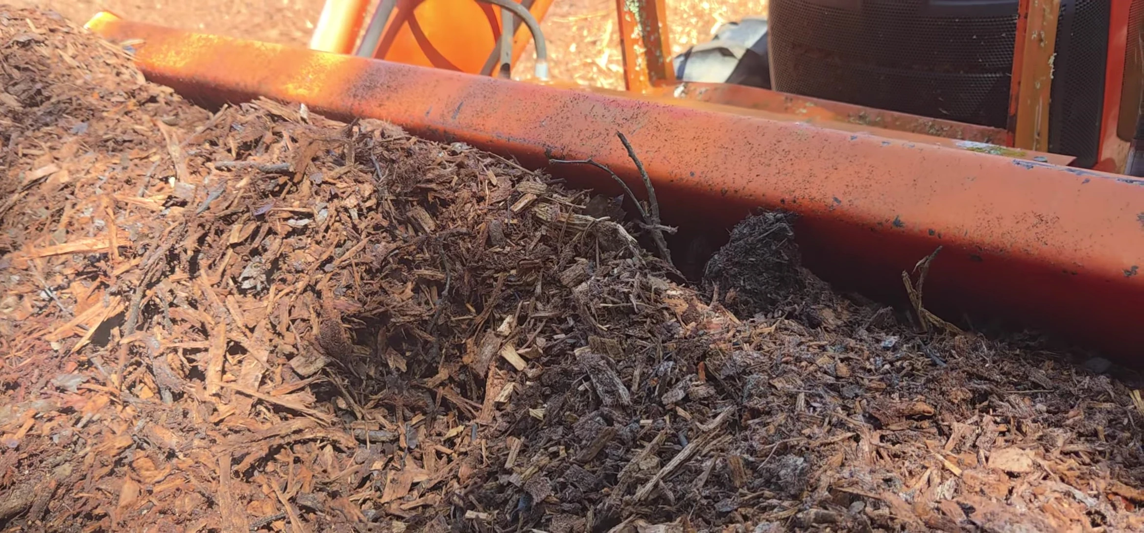Steam rising from the wood chip pile, indicating decomposition.