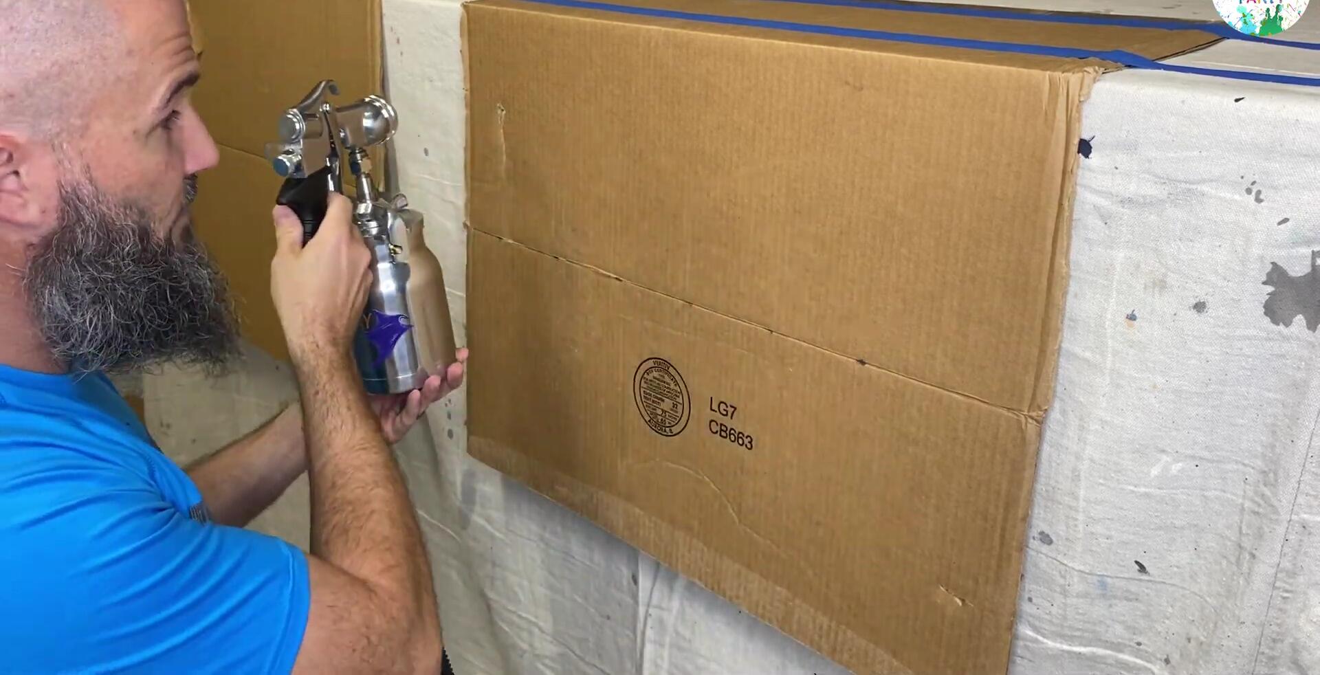Testing the spray pattern with water on cardboard.