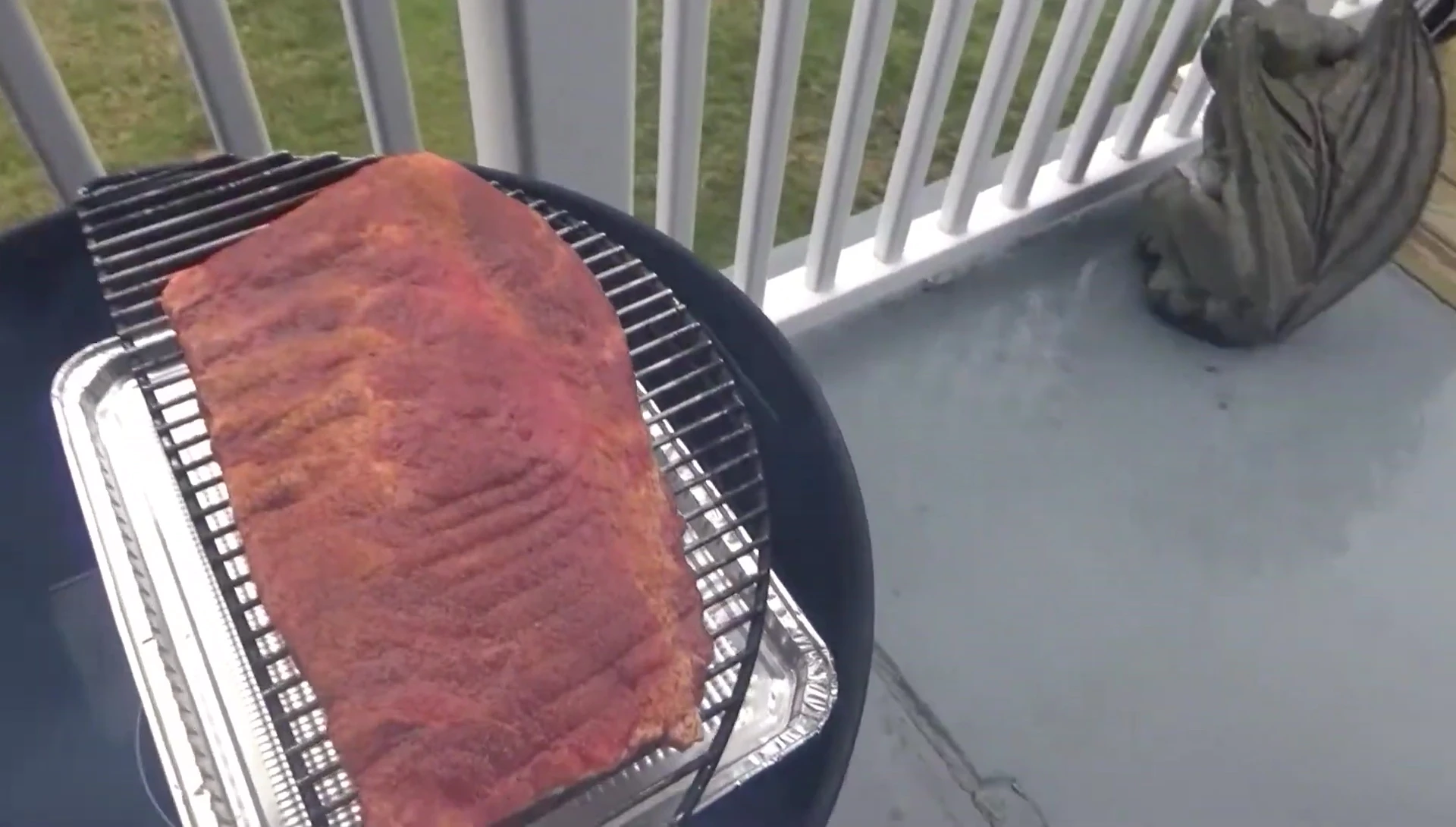 Closing the lid of the pellet grill.