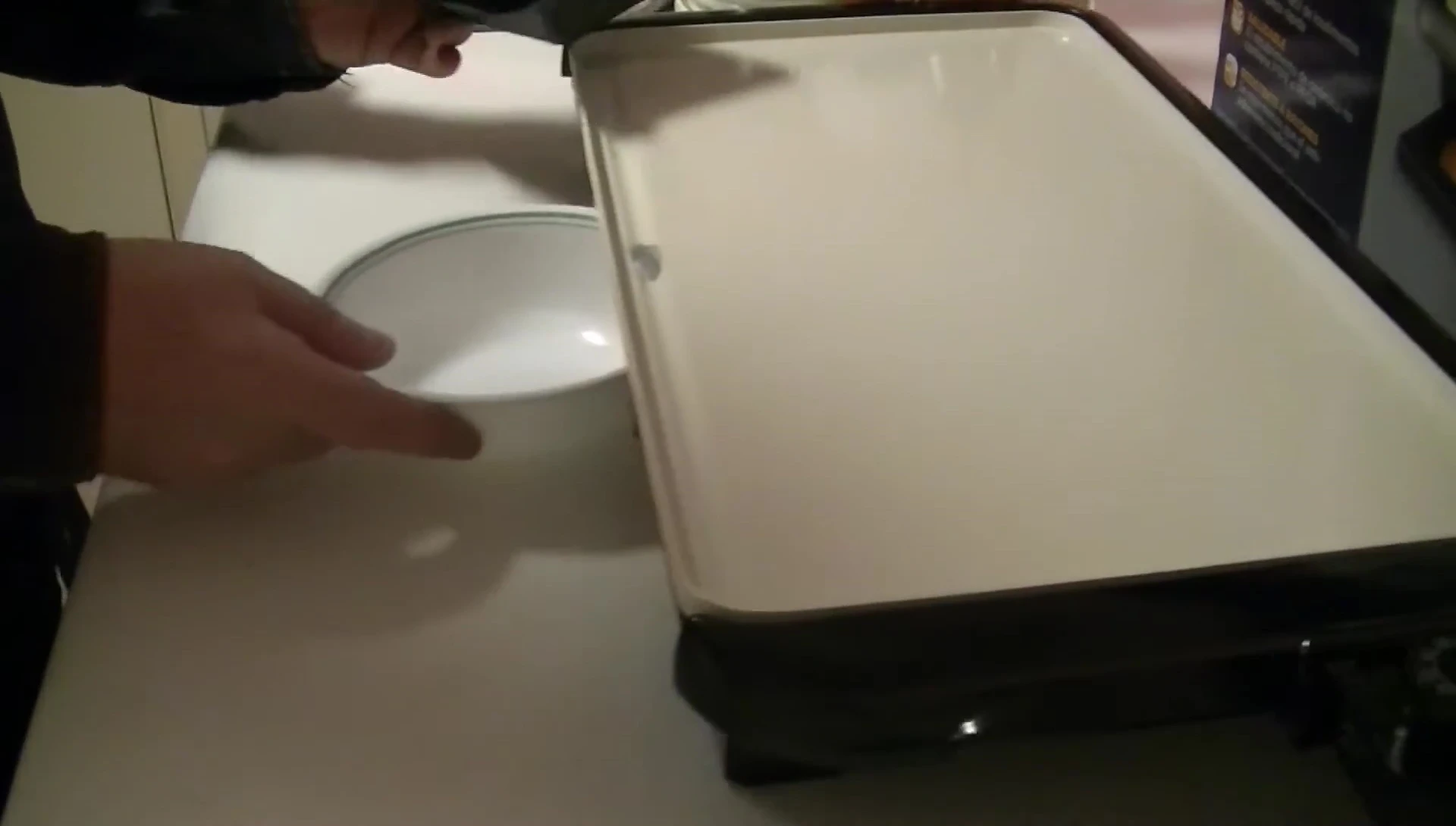 Close-up shot showing a bowl fitting under the elevated griddle to catch grease.