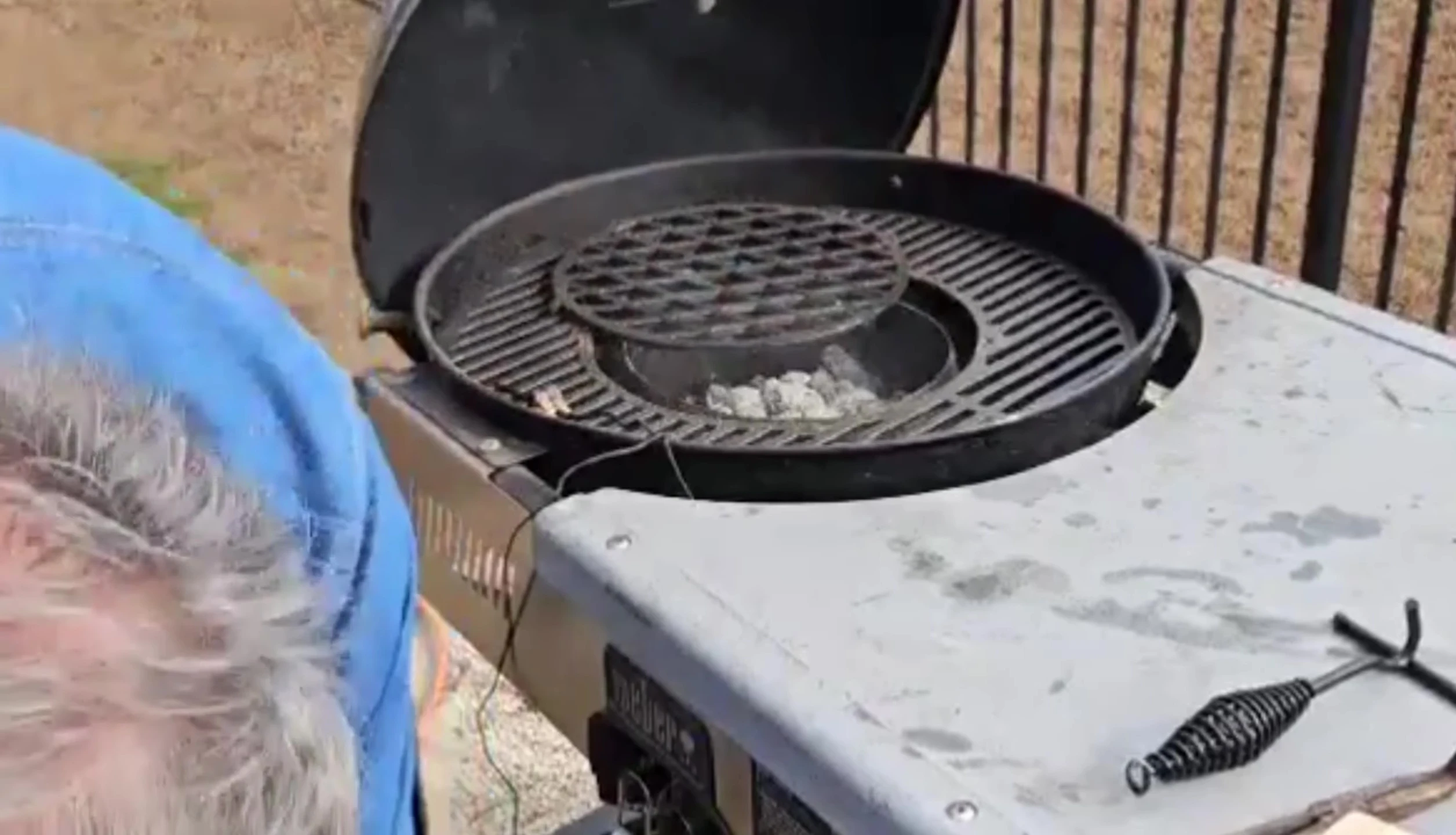 Adding hickory wood to the grill.
