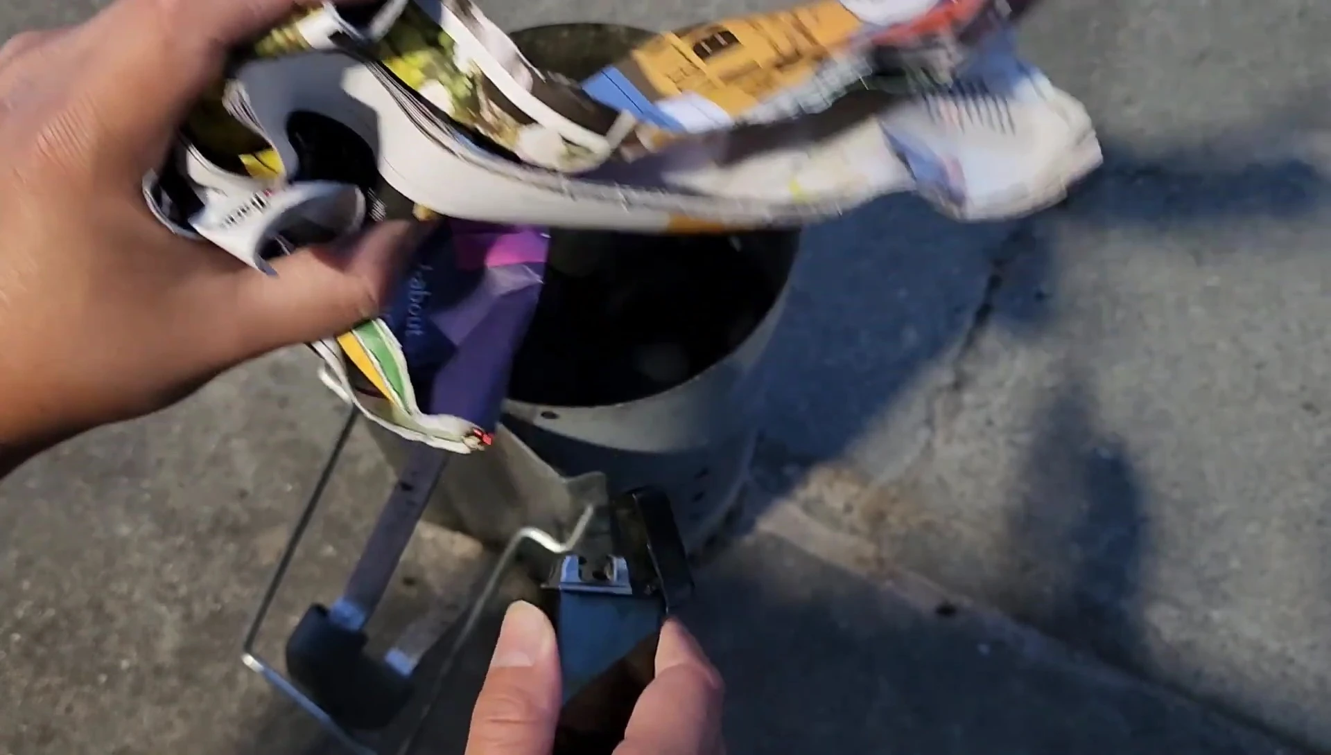 Attempting to light briquettes with junk mail