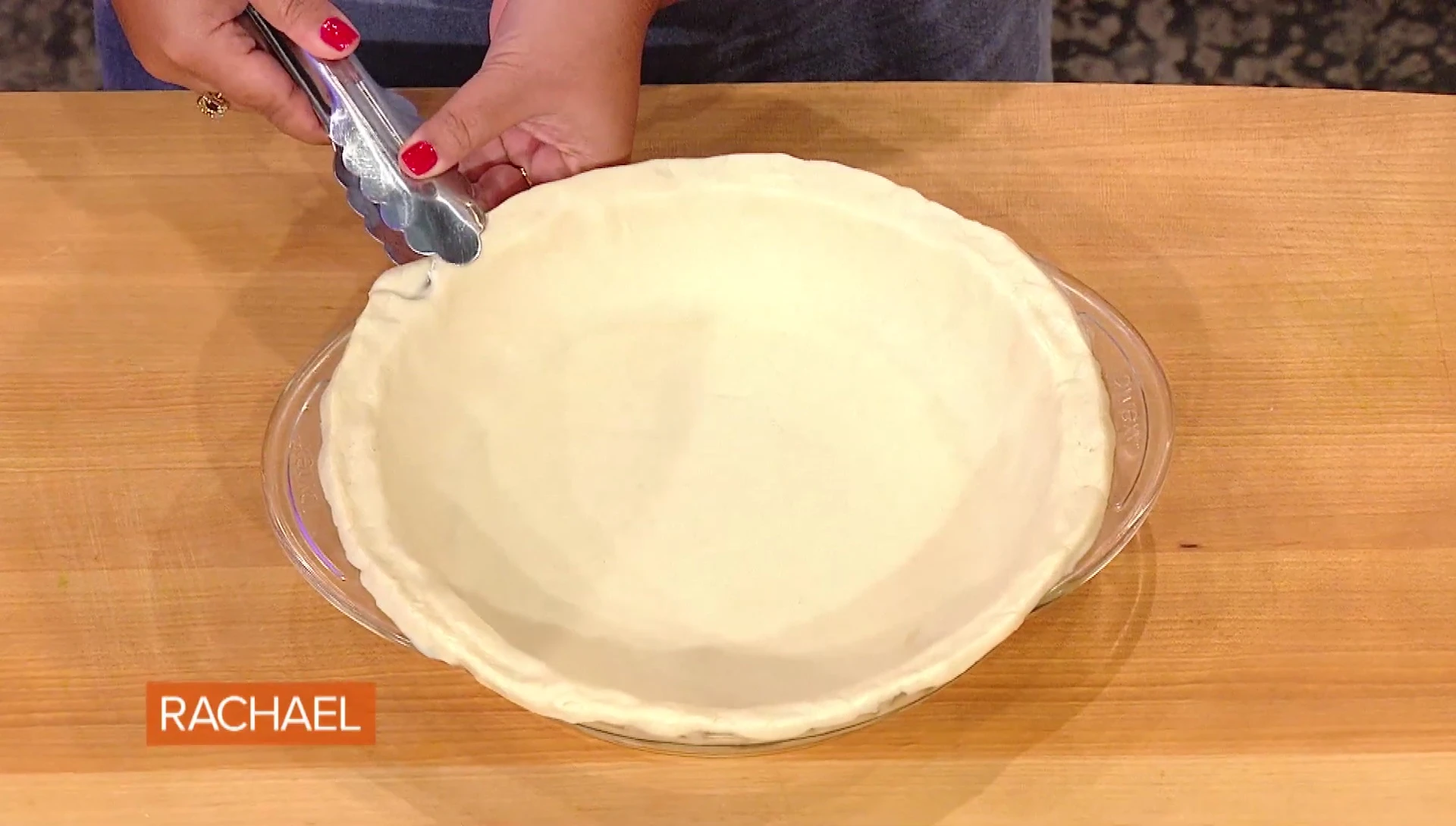 Close-up demonstration of crimping the pie crust with tongs.